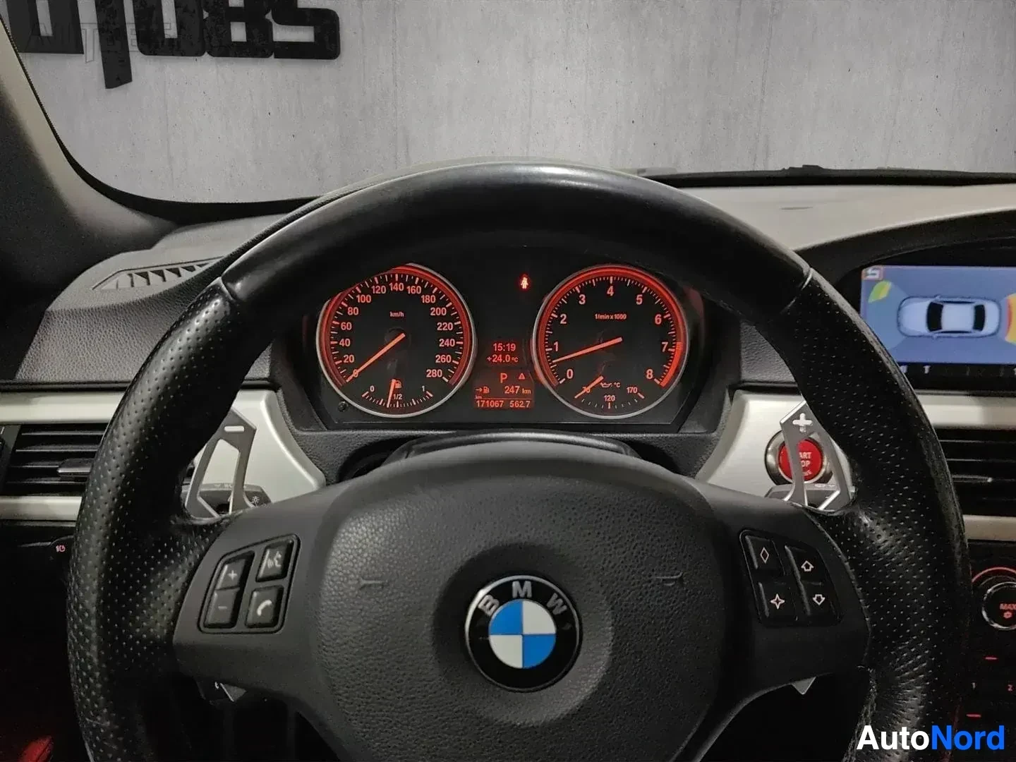 Ohjaamo: BMW:n ohjauspyörä ja punainen instrumenttinäyttö, näkyy matkamittari ja kierroslukemittari
