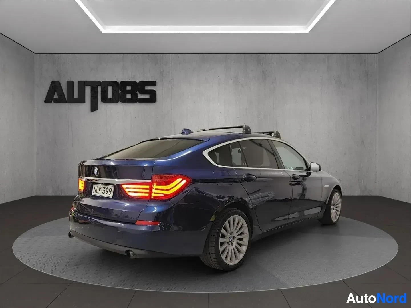 Takaviisto: Tummansininen BMW Gran Turismo takaa katsottuna, LED-takavalaisimet näkyvissä, kattotelineillä, rekisterikylpi