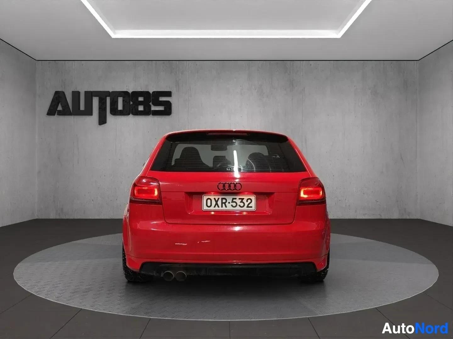 Takaa: Punainen Audi-auto näkyy takaa studiossa.