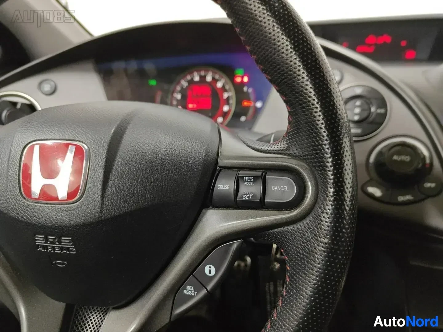 Ohjaamo: Ohjauspyörän yksityiskohta: Honda-tunnus näkyvissä, ratin päällä nauhamittausilmaisin ja matkamittausnapit