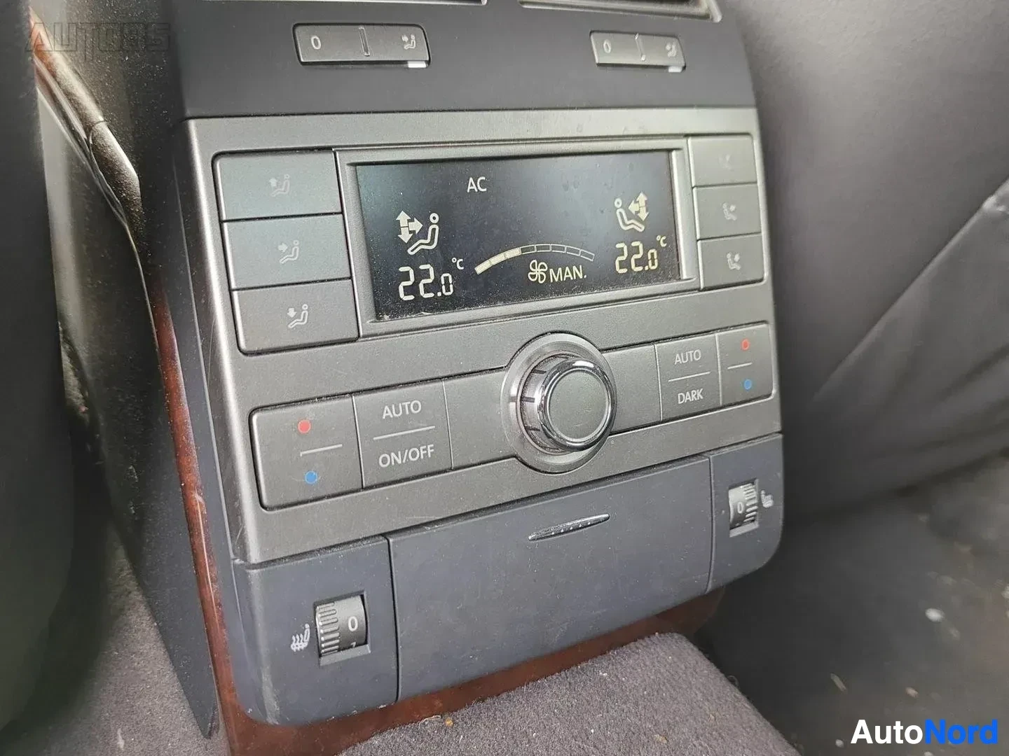 Yksityiskohta: Kahden vyöhykkeen ilmastointi paneeli, näyttöön ilmiintyy AC-teksti ja lämpötila-asetukset 22,0°C, MAN. -merkkaus, AUTO ja DARK painikkeet