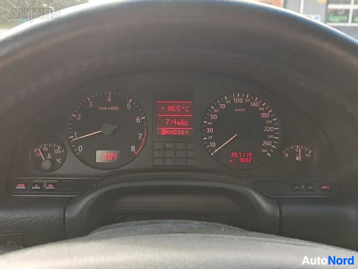 Yksityiskohta: Nopeusmittari ja bensiinimittari. Näytössä 7.4 l/100km kulutus, RND321-koodin näyttö, 351119 km lukema, +18,5°C lämpötila.