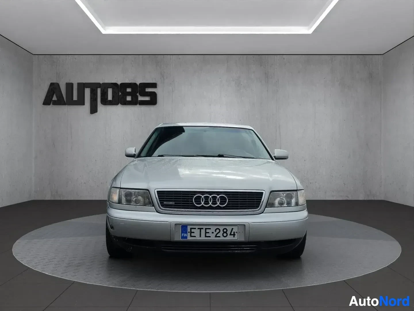 Edestä: Hopeanvärinen Audi A8 quattro V8 1994, jossa on mustat vanteet, kuvattuna suoraan edestä.