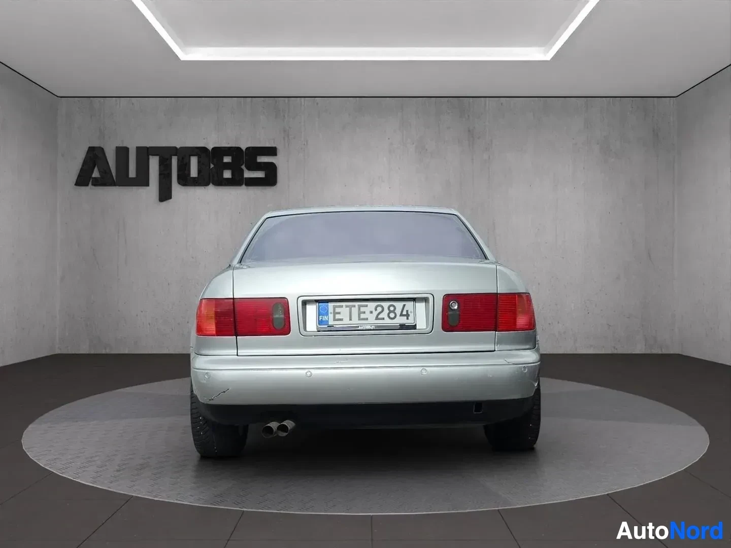 Takaa: Hopeanvärinen Audi A8 quattro V8 1994, jossa on kaksi pakoputkenpäätä, kuvattuna suoraan takaa.