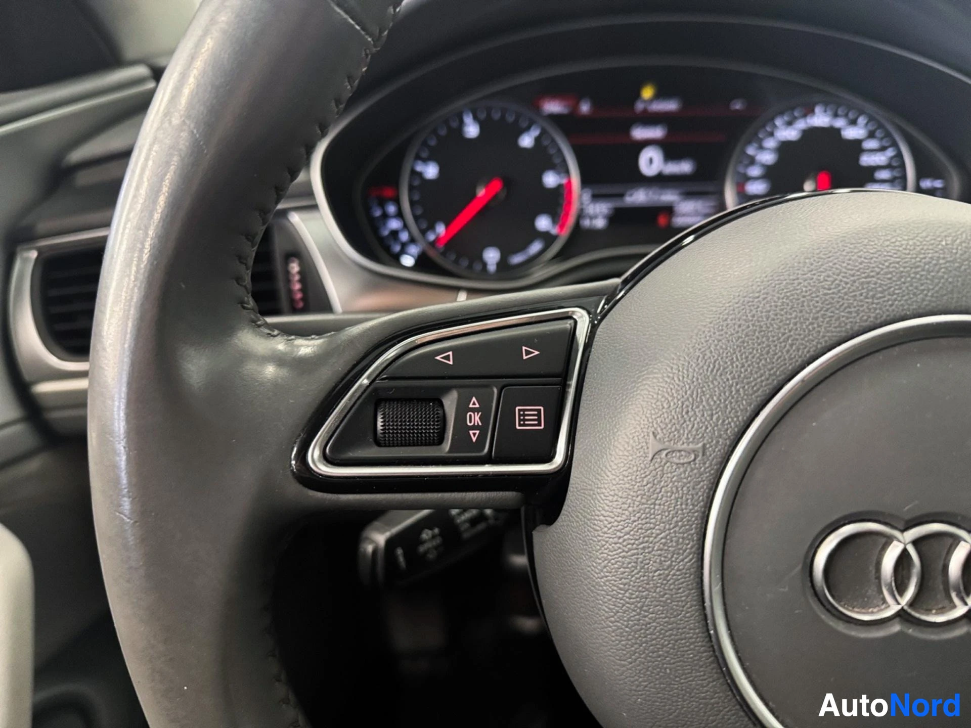Steering wheel with Audi logo and turn signal controls visible