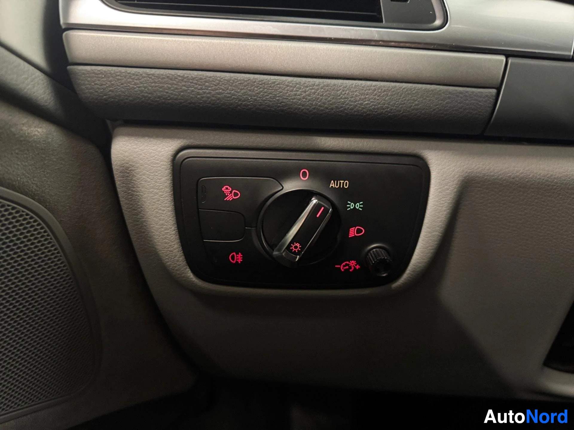 Headlight control panel with auto function and red symbols on beige dashboard