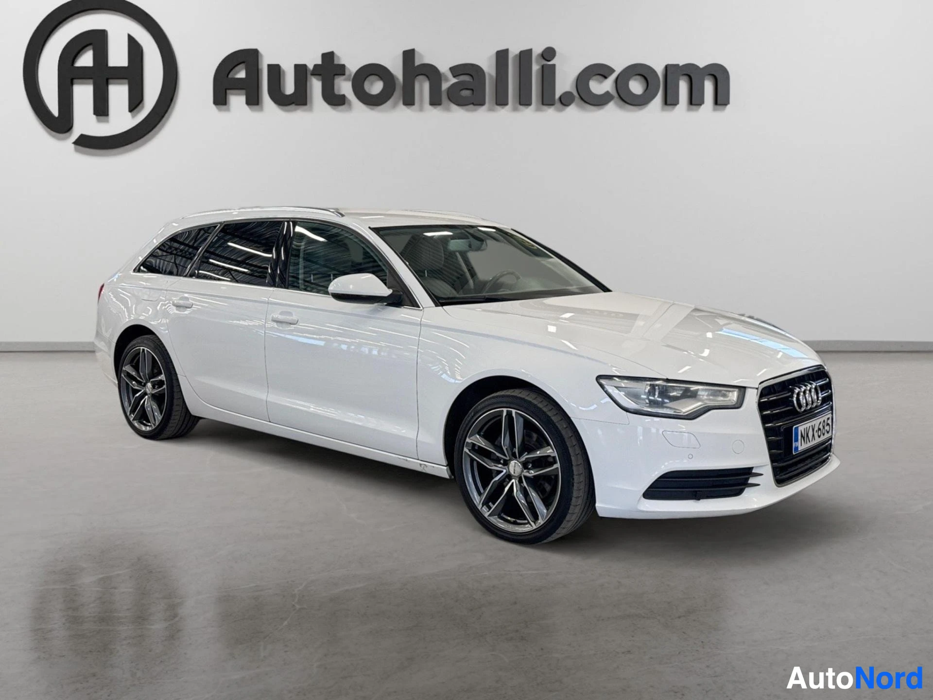 Valkoinen Audi A6 Avant sivusta kuvattuna oikealle päin
