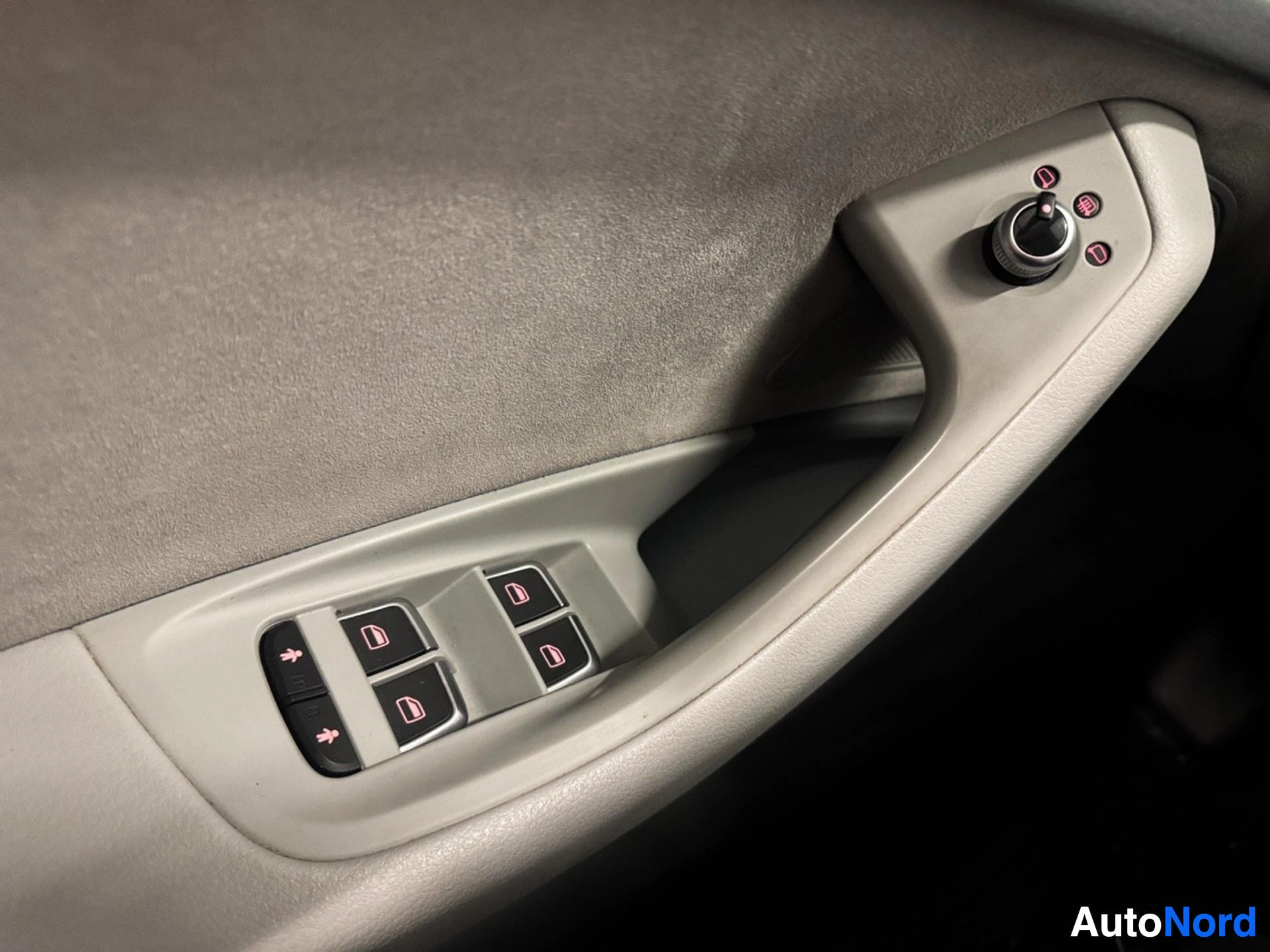 Door panel with window controls and mirror adjustment buttons in beige