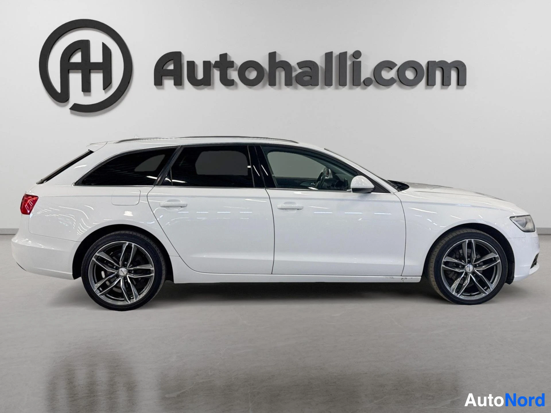 Valkoinen Audi A6 Avant sivusta kuvattuna vasemmalle päin, ovet auki