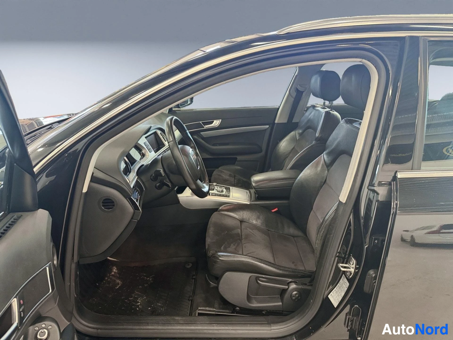 Interior front driver seat and steering wheel with dashboard visible