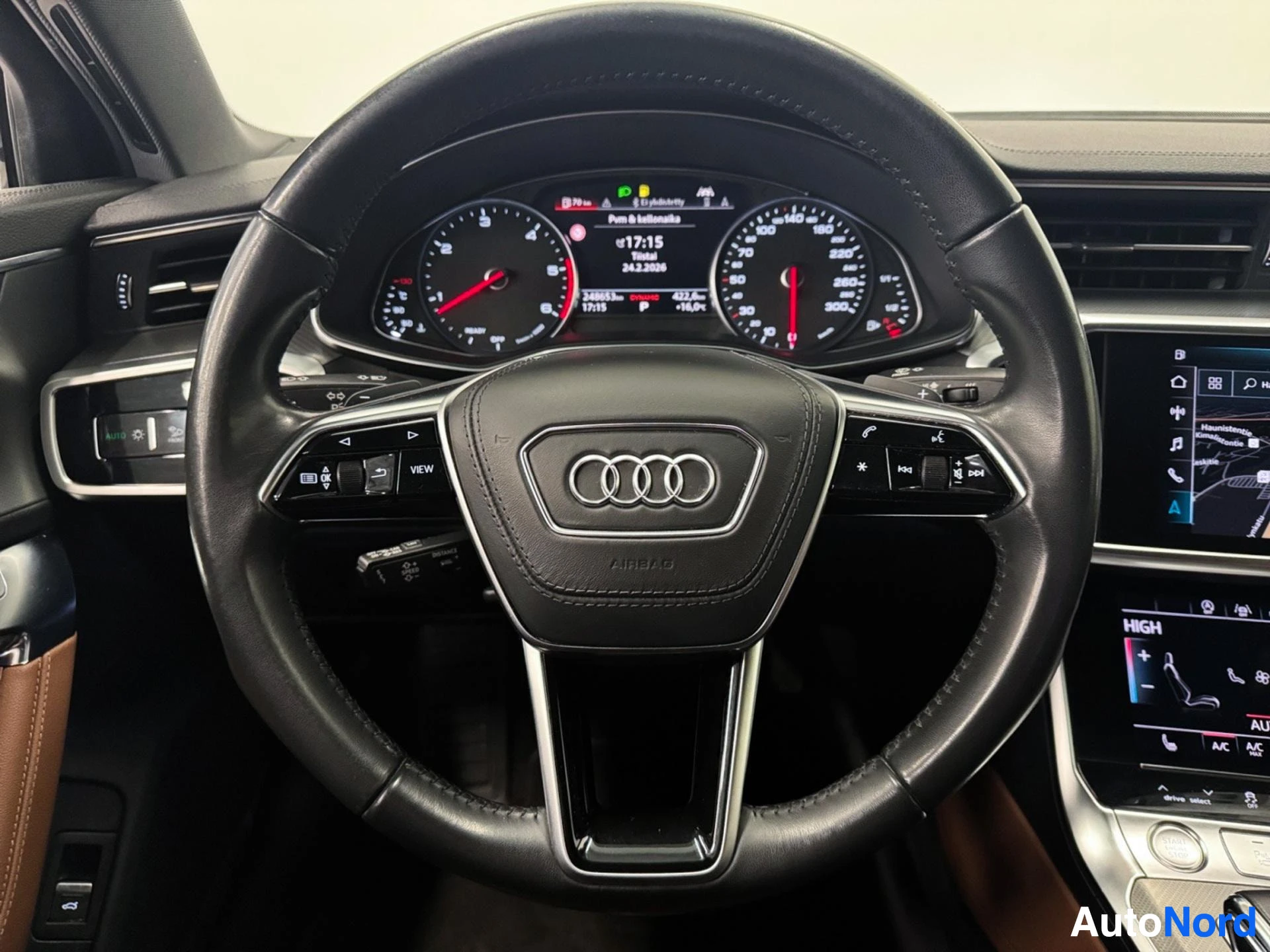 Black leather steering wheel with Audi logo and control buttons, dashboard visible