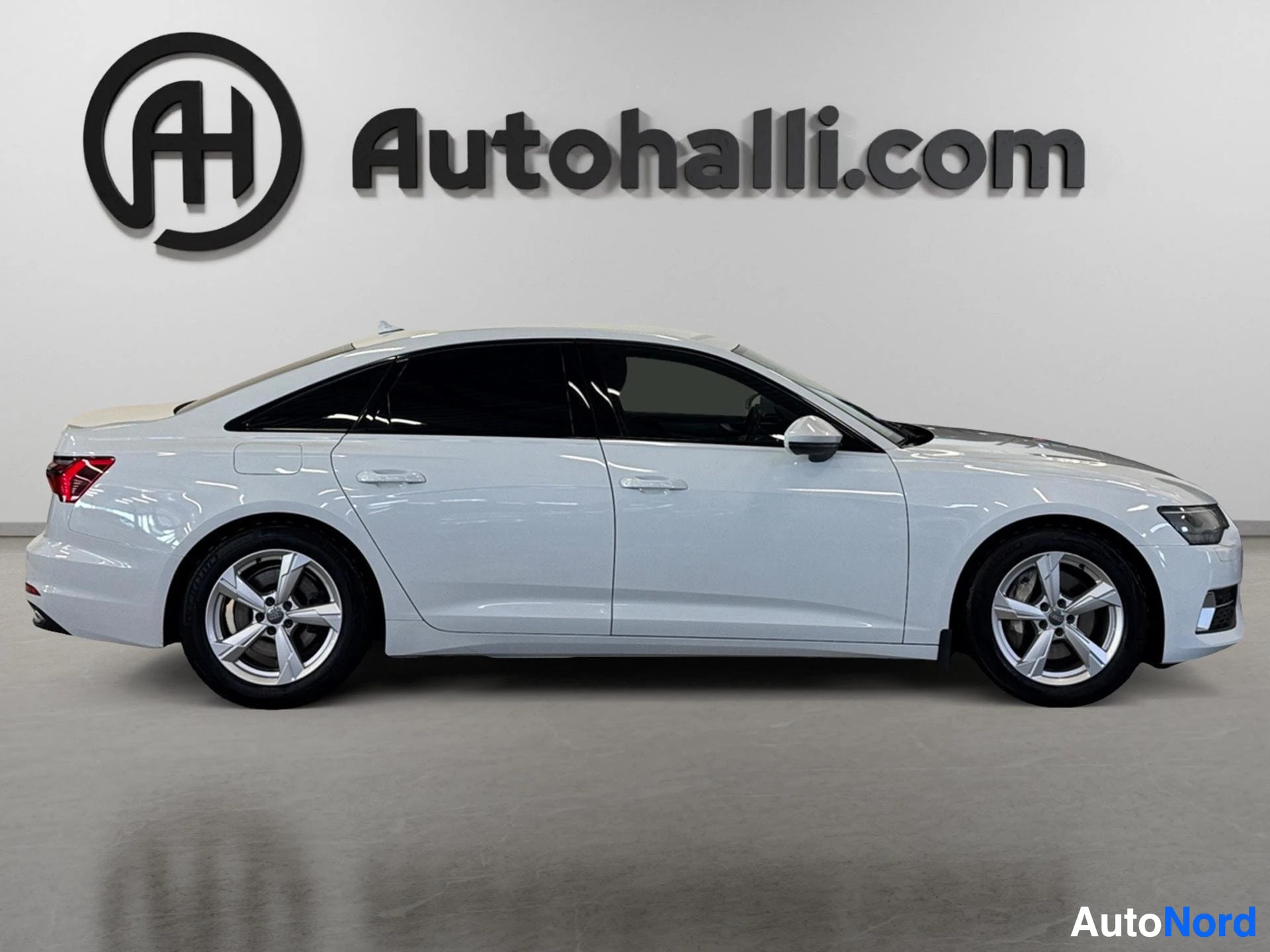 Valkoinen Audi A6 sedan sivunäkymä vasemmalta puolelta