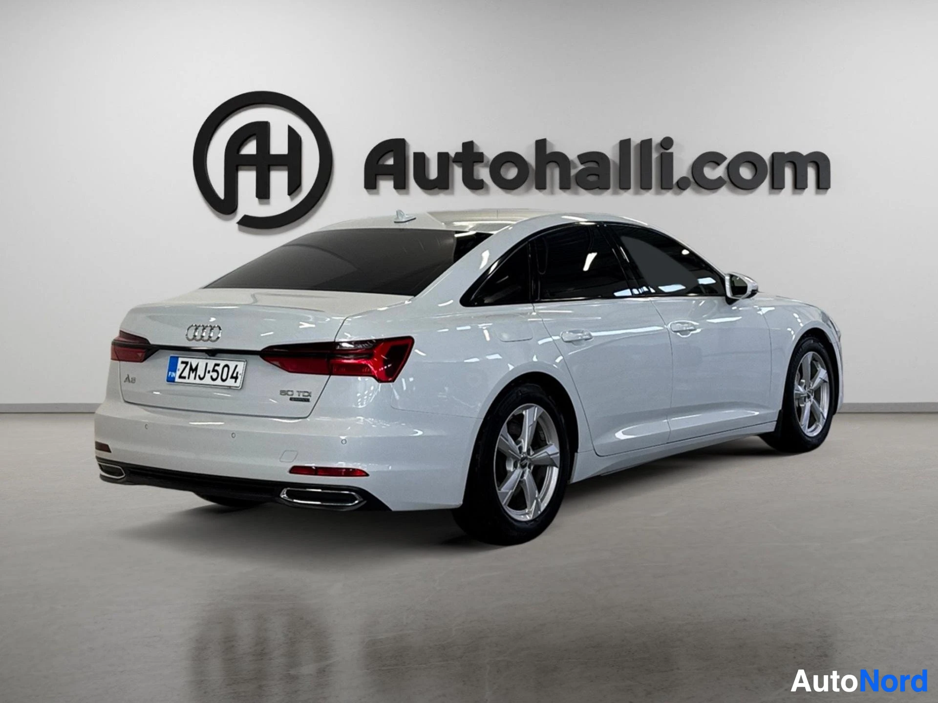 Valkoinen Audi A6 sedan takaa kuvattuna, takalyhtyjen näkyvissä