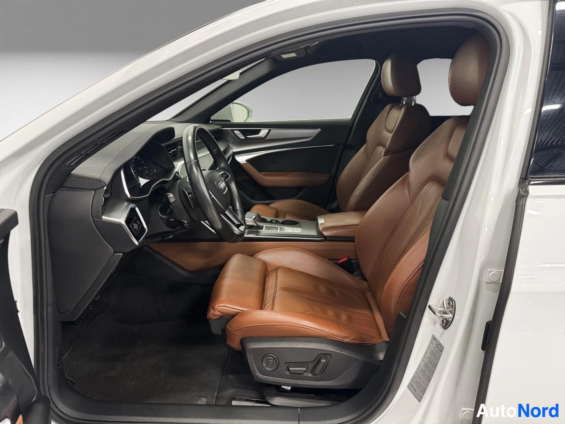 Audi A6 interior with brown leather seats, steering wheel, and dashboard
