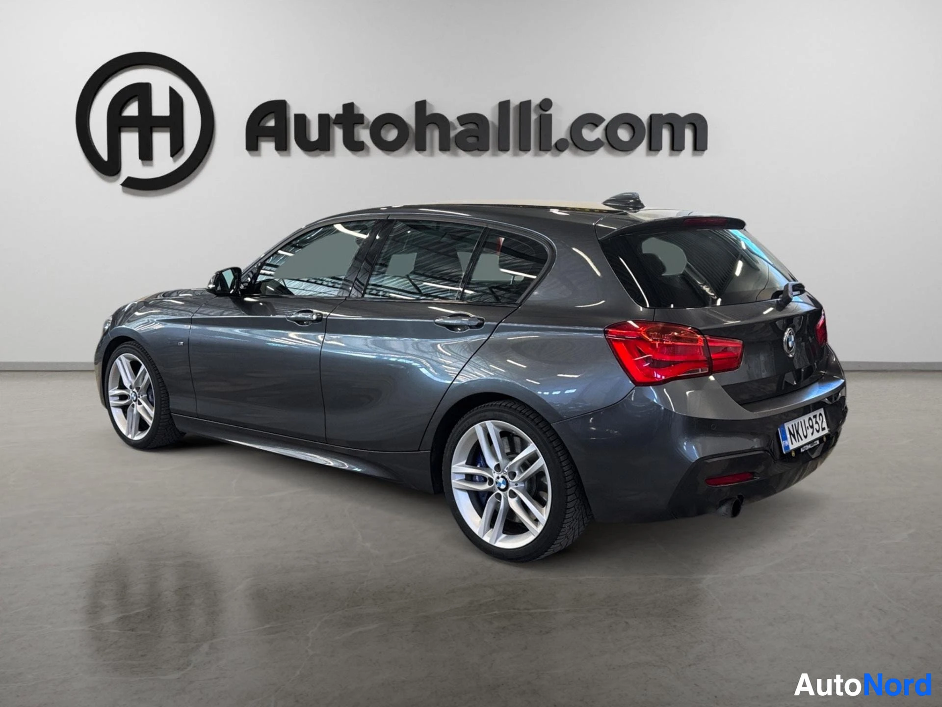 Tummansininen BMW hatchback näkyy kulmakulma etupuolelta taakse