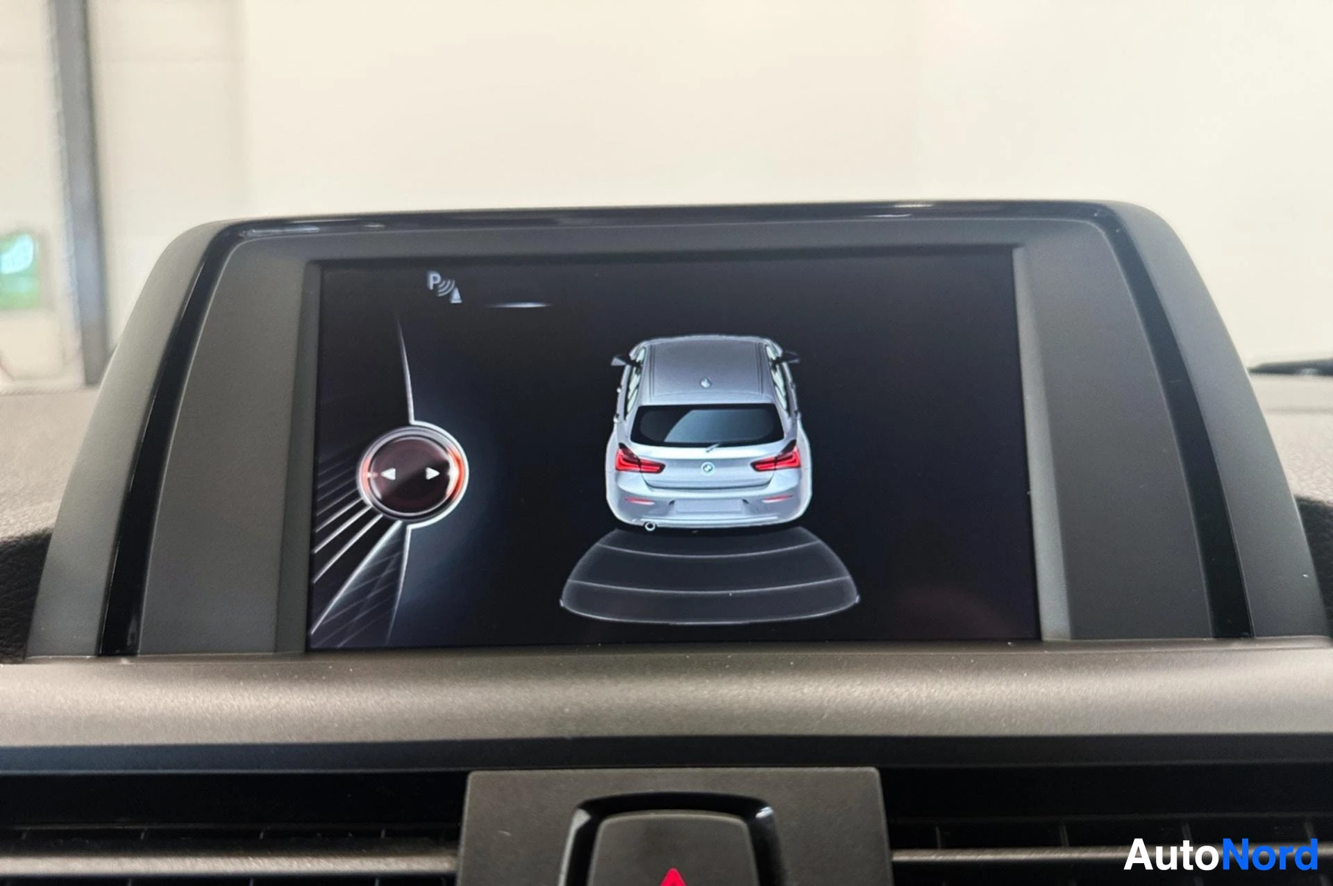 Infotainment display showing parking sensor visualization with car top view.