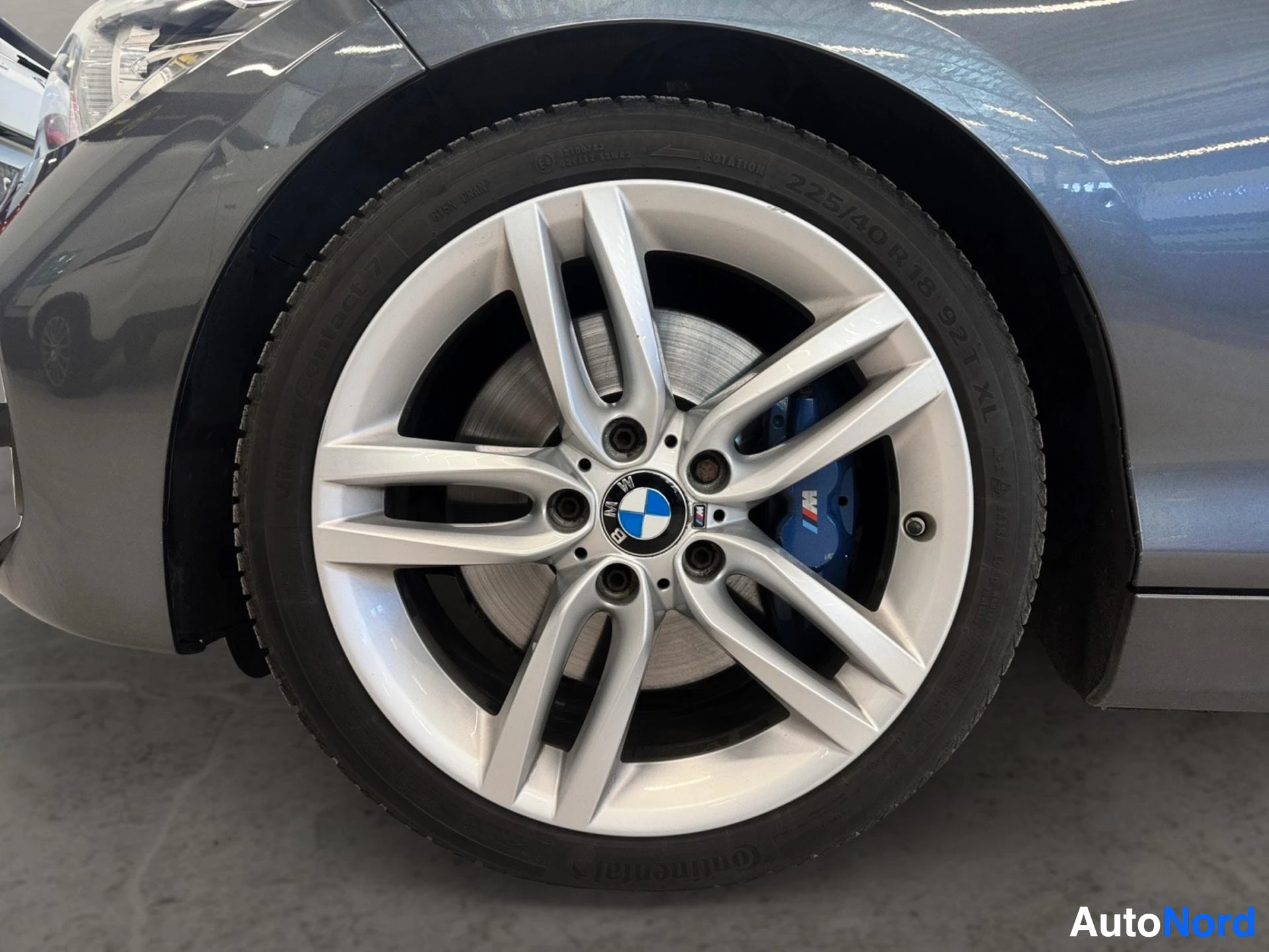 Light alloy wheel with silver finish and blue brake calipers