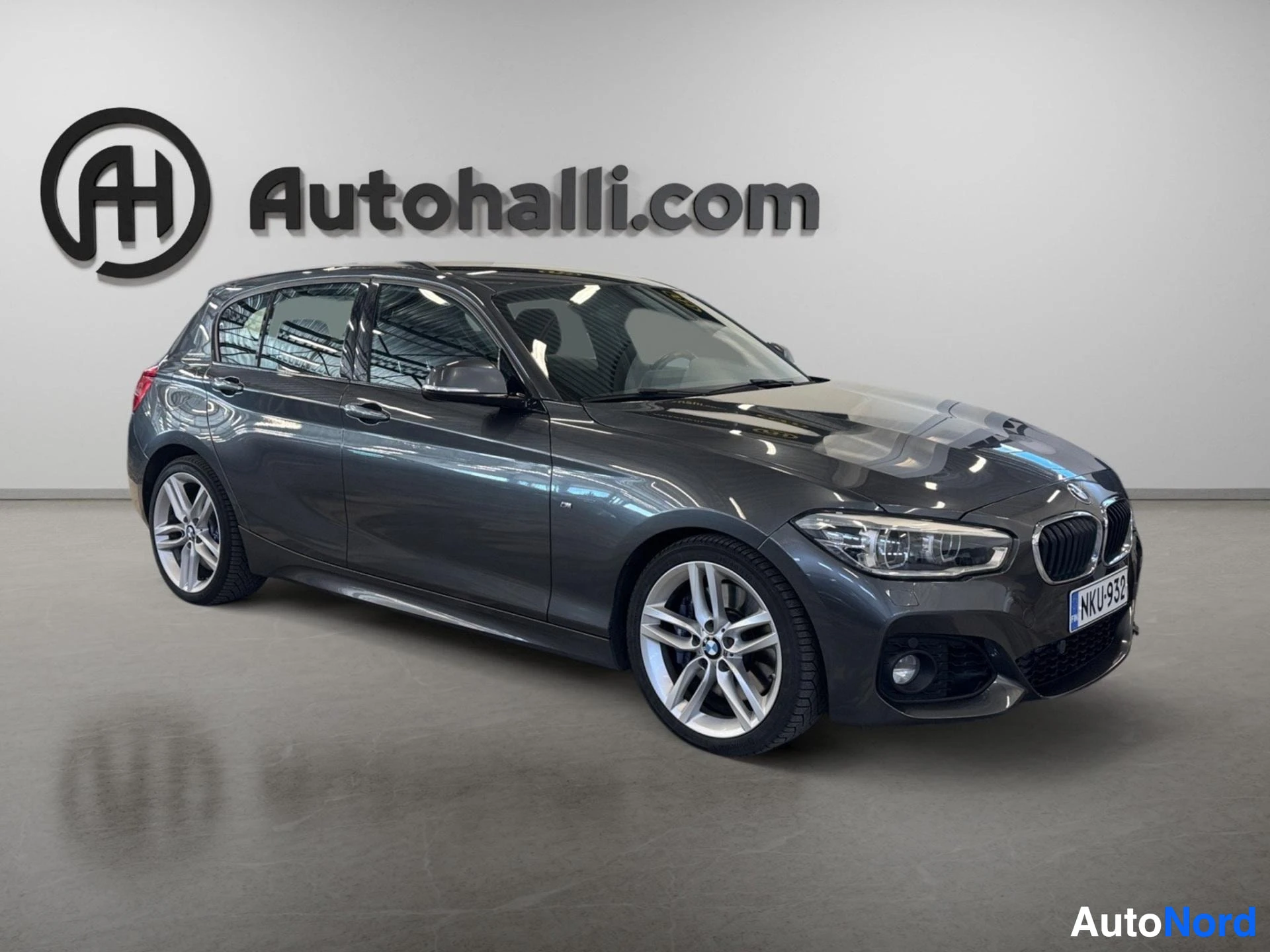 Tummansininen BMW hatchback oikealta sivulta kameraan päin