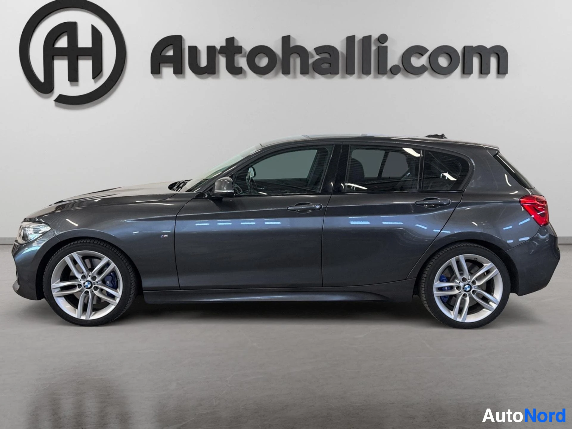 Tummansininen BMW hatchback näkyy sivulta vasemmalta oikealle päin