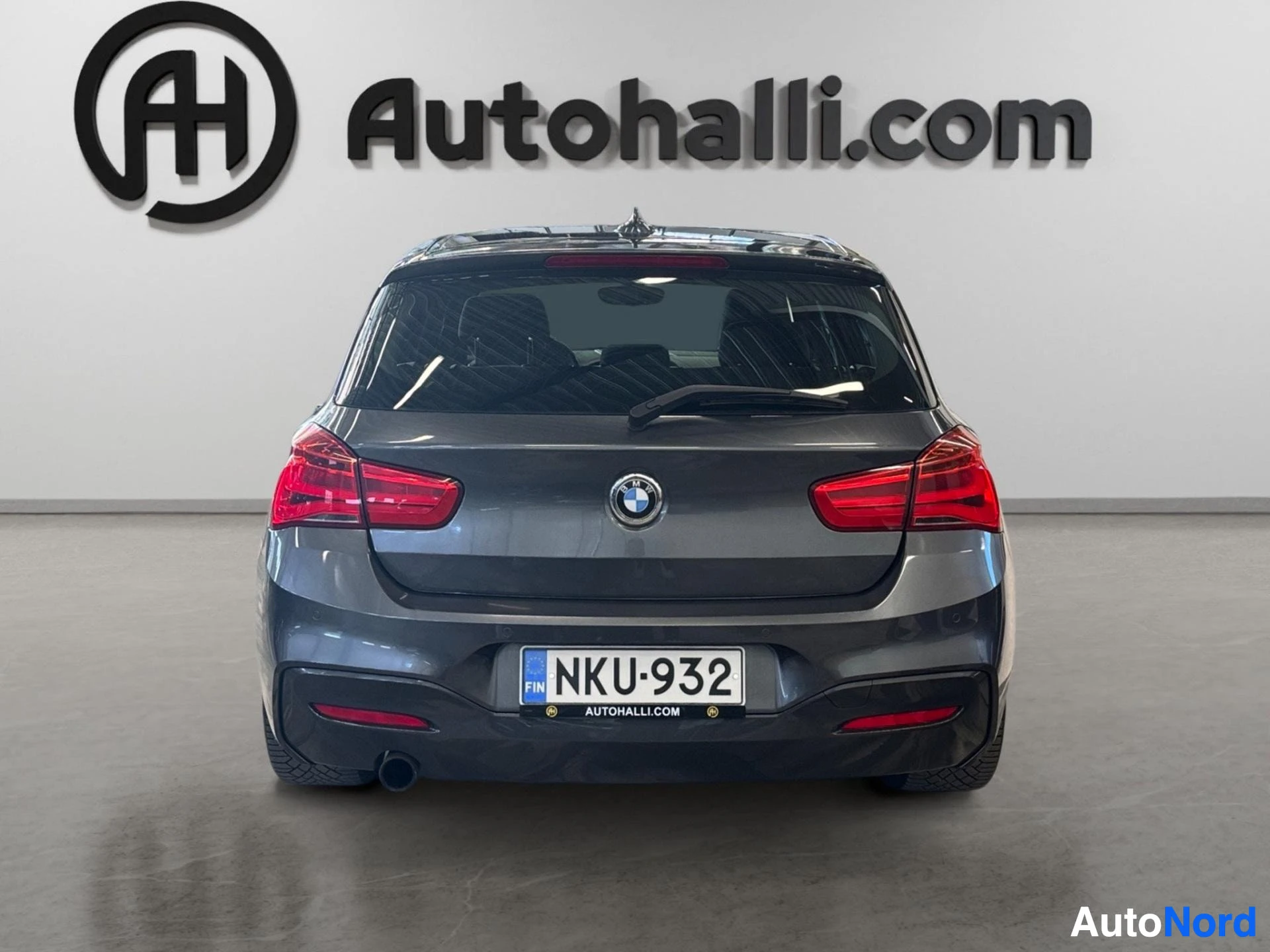 Tummansininen BMW hatchback näkyy suoraan takaa punaisilla takavalolla