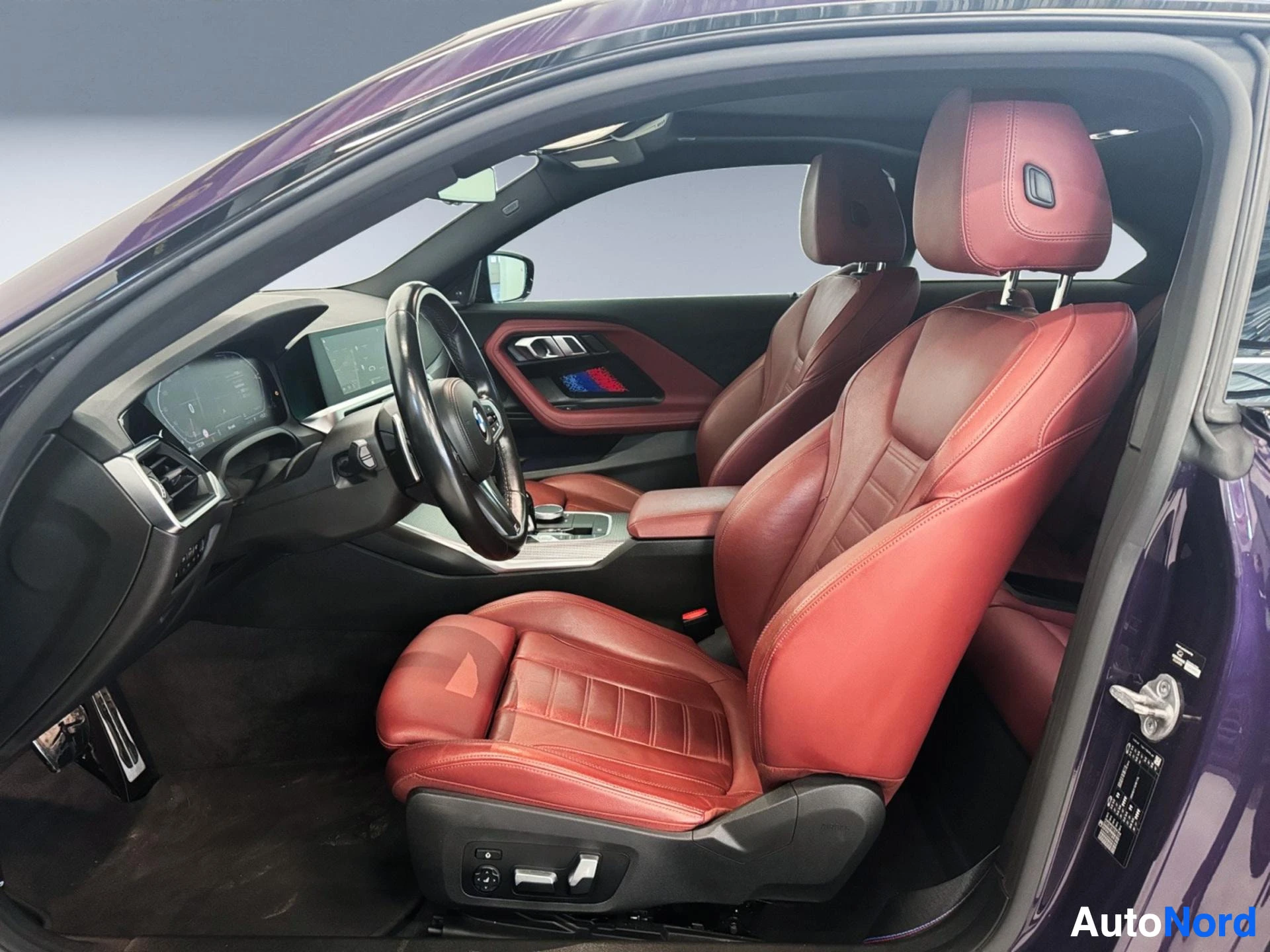 Side view of interior showing red leather seats and door panels