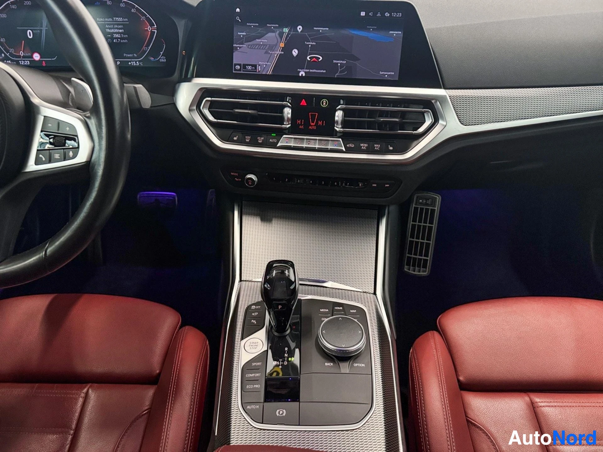 BMW center console with gear shift, infotainment display and red leather seating
