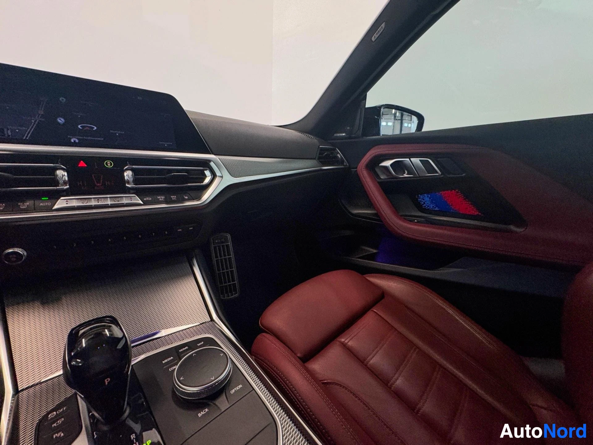 Interior cabin showing burgundy leather seats, steering wheel, and dashboard.