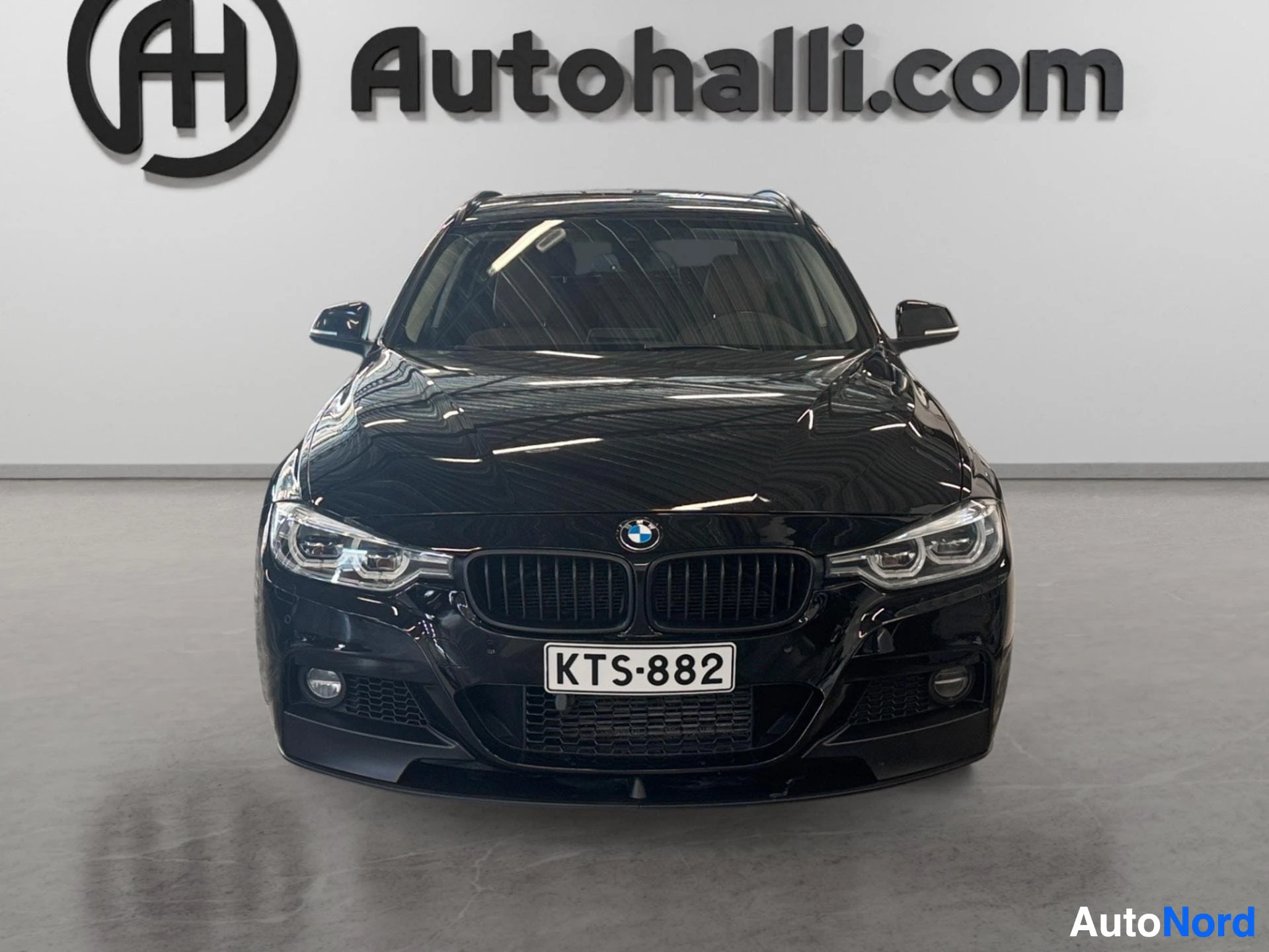 Musta BMW farmari suoraan edestä, kaksois-LED-ajovalot, mustaan säleikköön