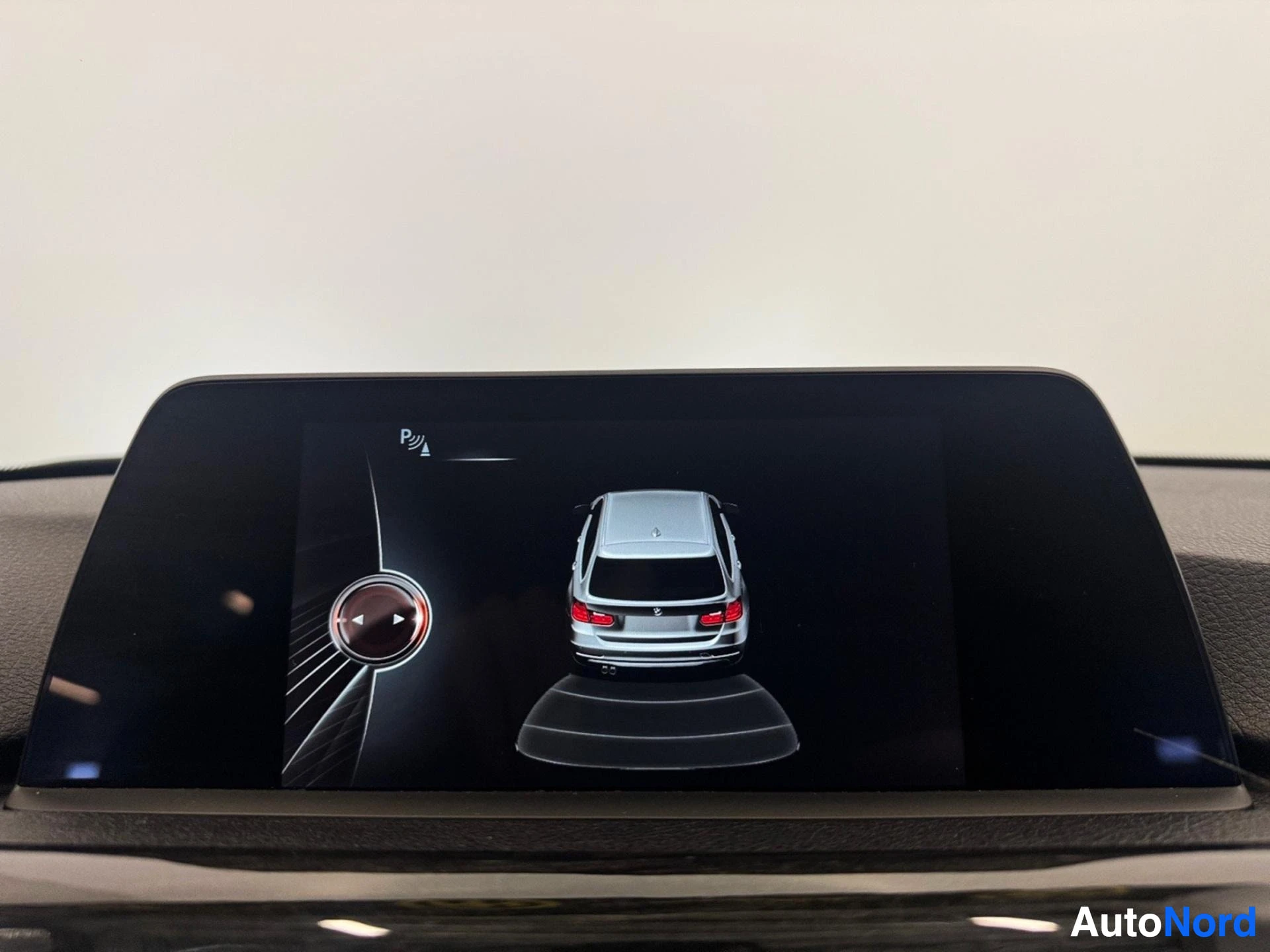 Infotainment display showing 360-degree camera view and parking sensors