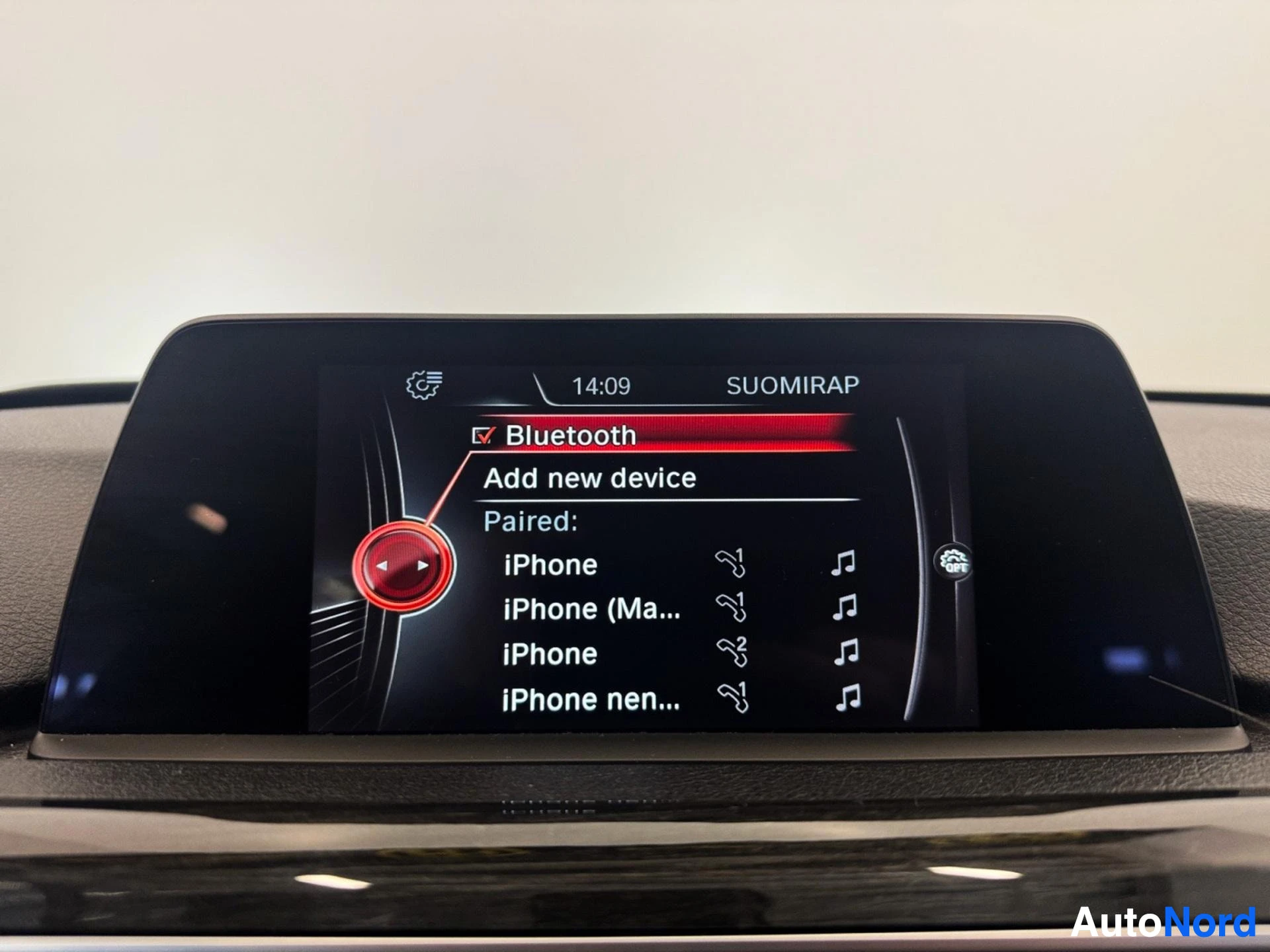 Infotainment display showing Bluetooth pairing menu with paired iPhones