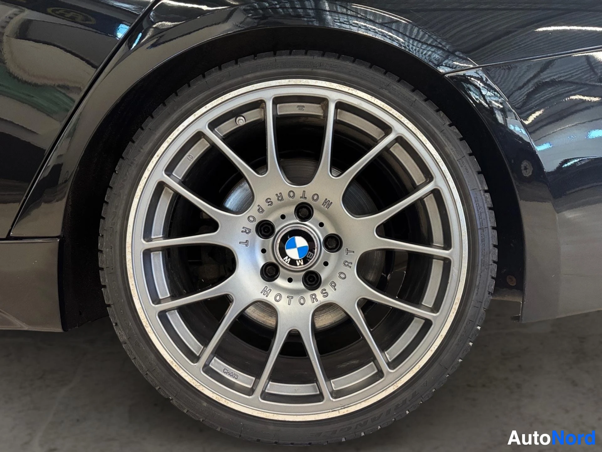 Hopeanväriset alumiiniventtiilit ja BMW-tunnus pyörässä, musta rengas