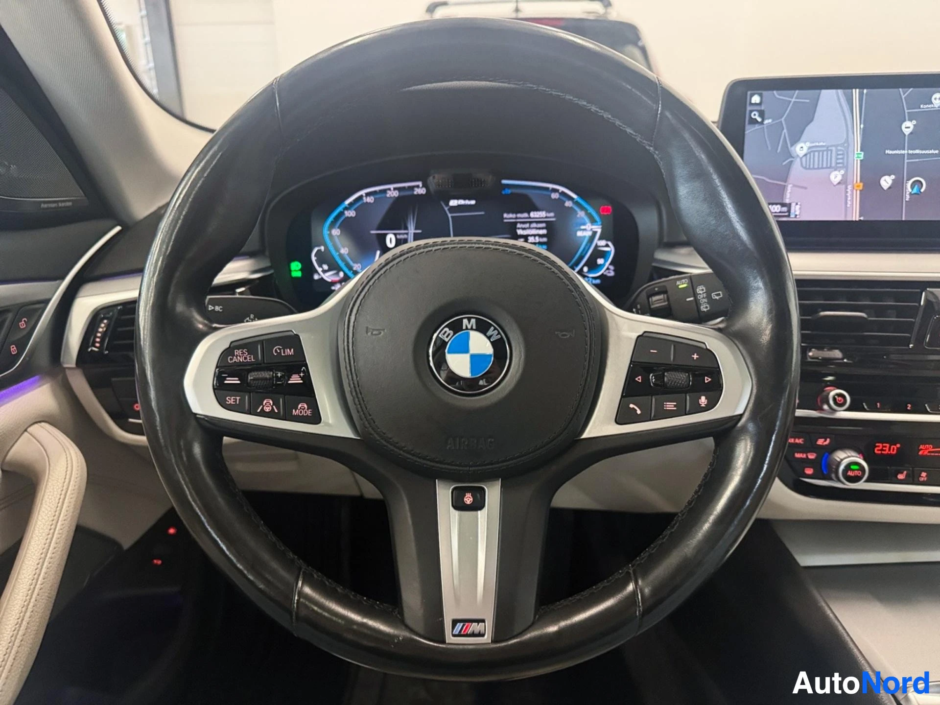 Steering wheel with BMW logo and control buttons facing forward