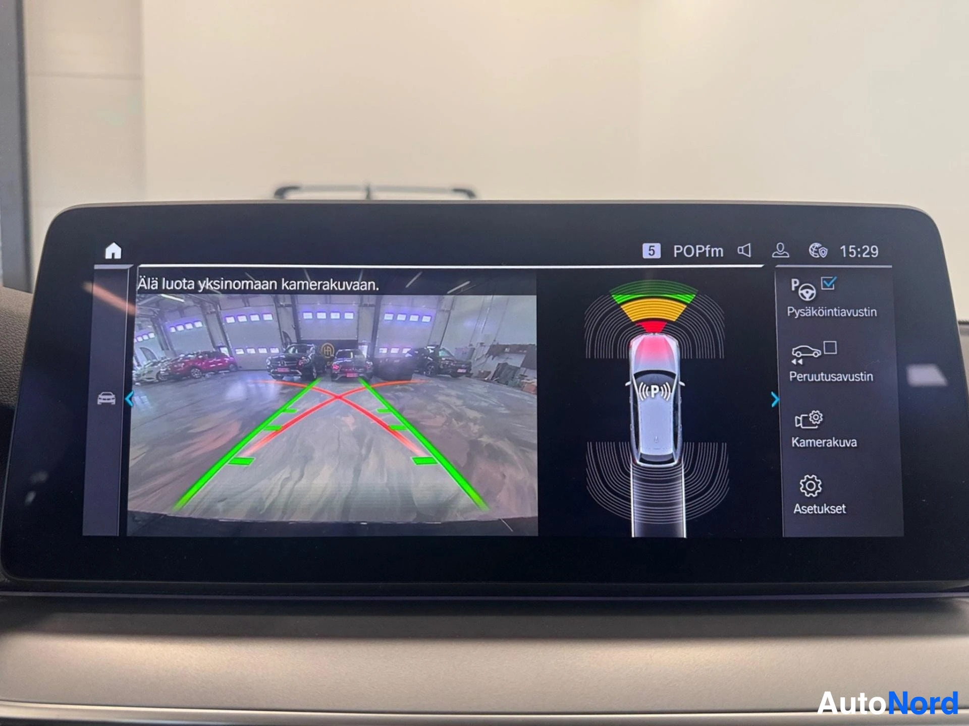 Infotainment screen displaying 360-degree parking camera and distance sensors