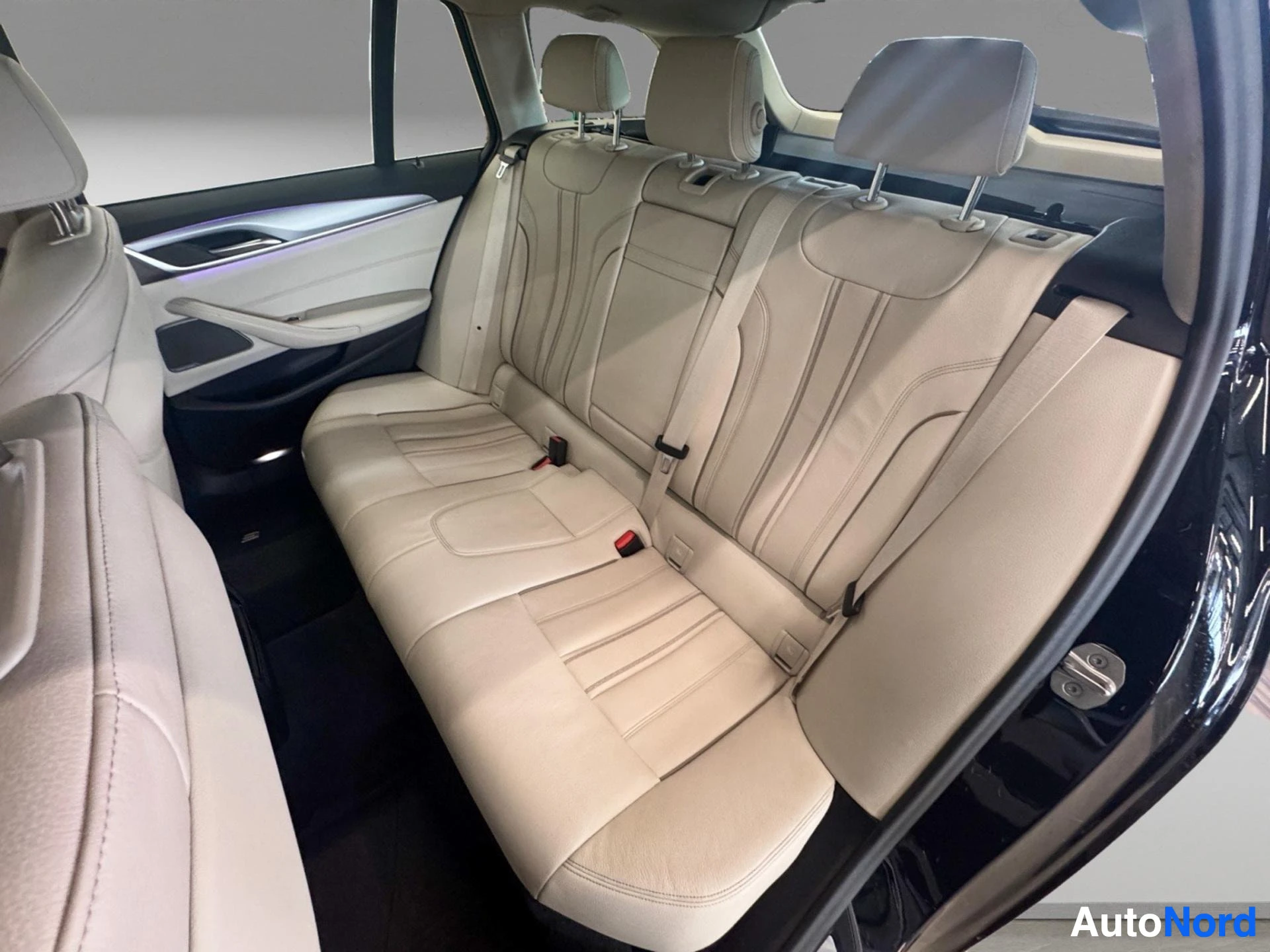 Rear seats with light leather upholstery and headrests visible