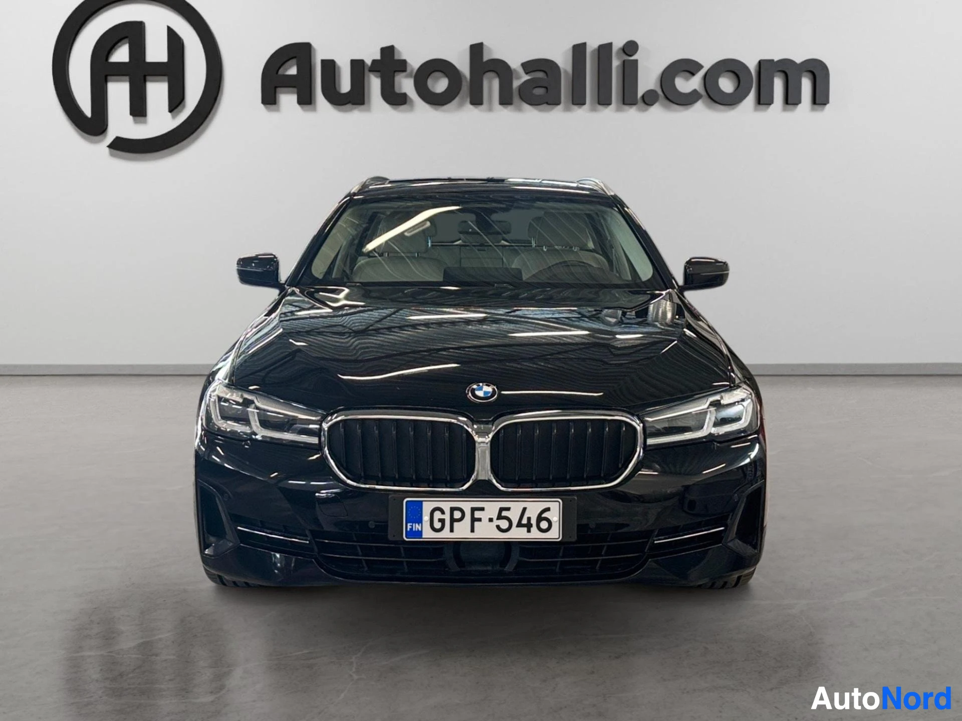 Black BMW Touring viewed head-on showing front grille and headlights