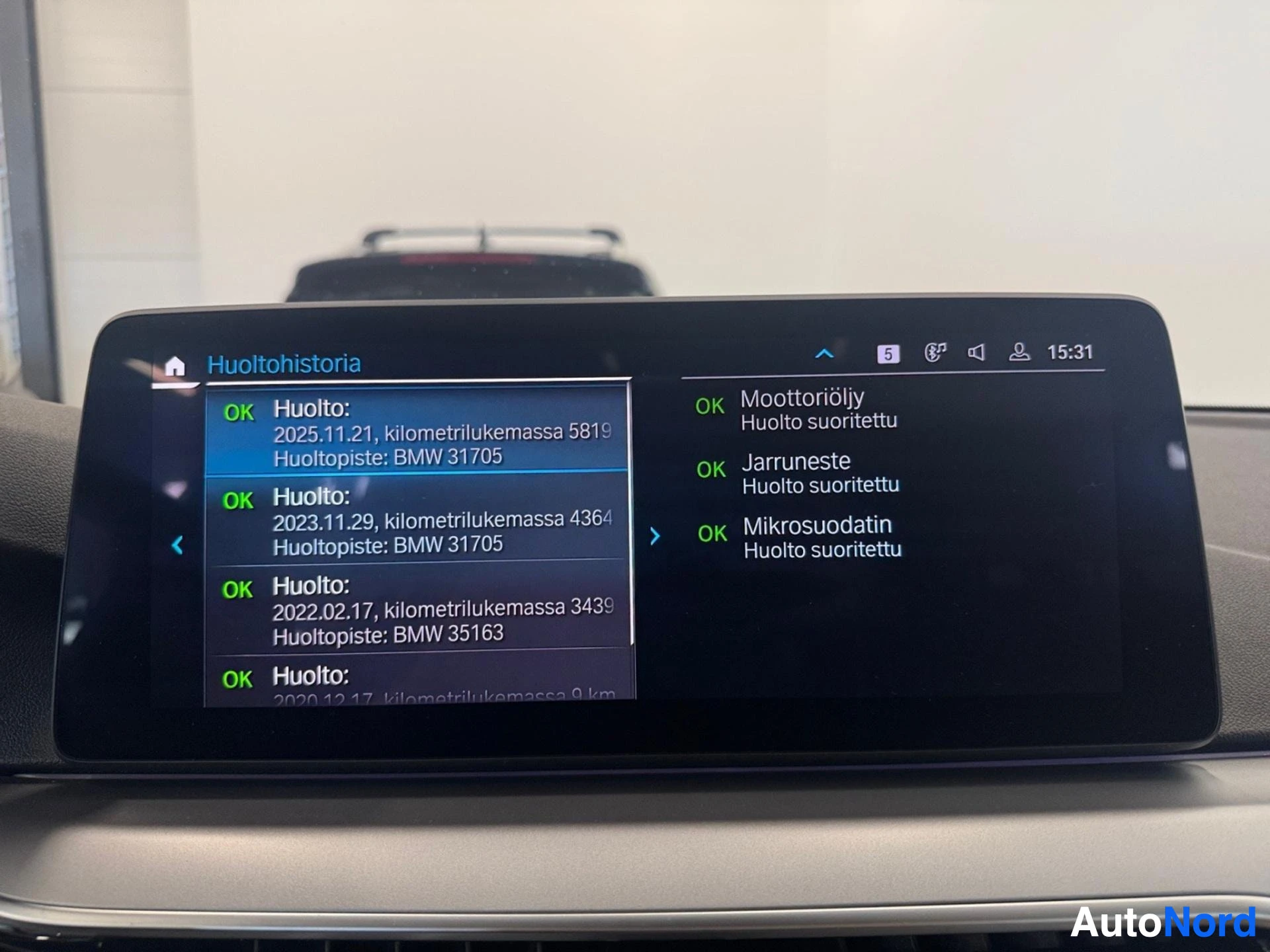 Infotainment display showing service history with maintenance records and dates.