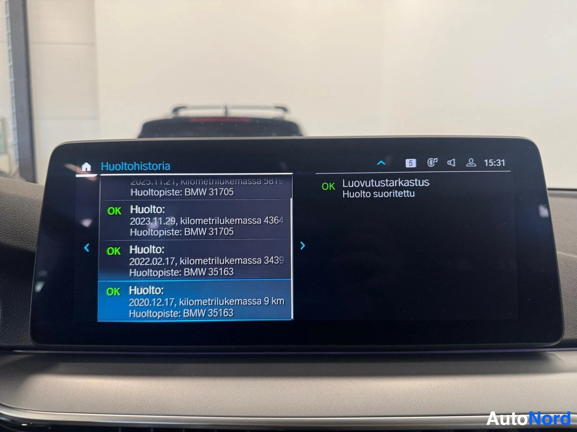 Infotainment display showing additional service history entries and maintenance information.