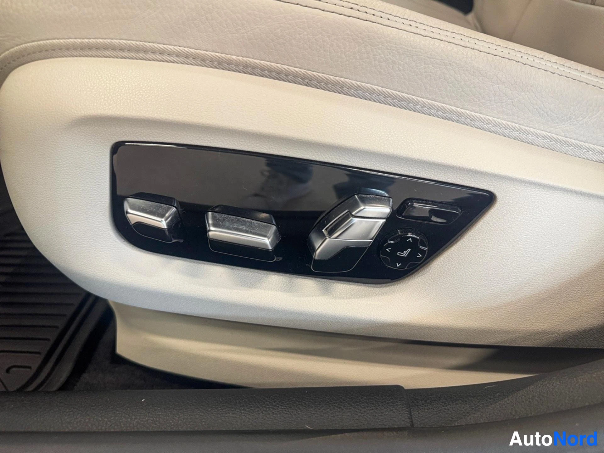 Beige leather seat adjustment controls with multiple buttons on door panel