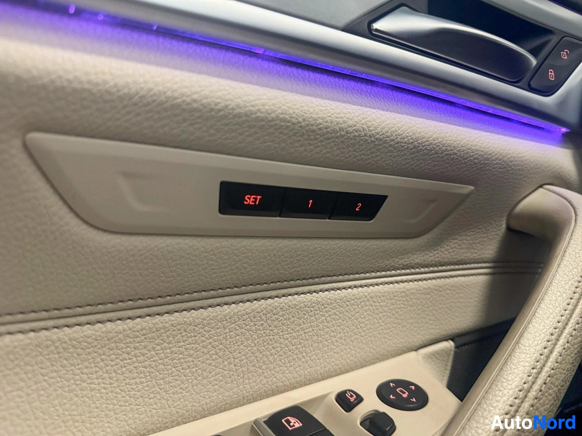 Purple ambient lighting above beige door panel with seat memory buttons