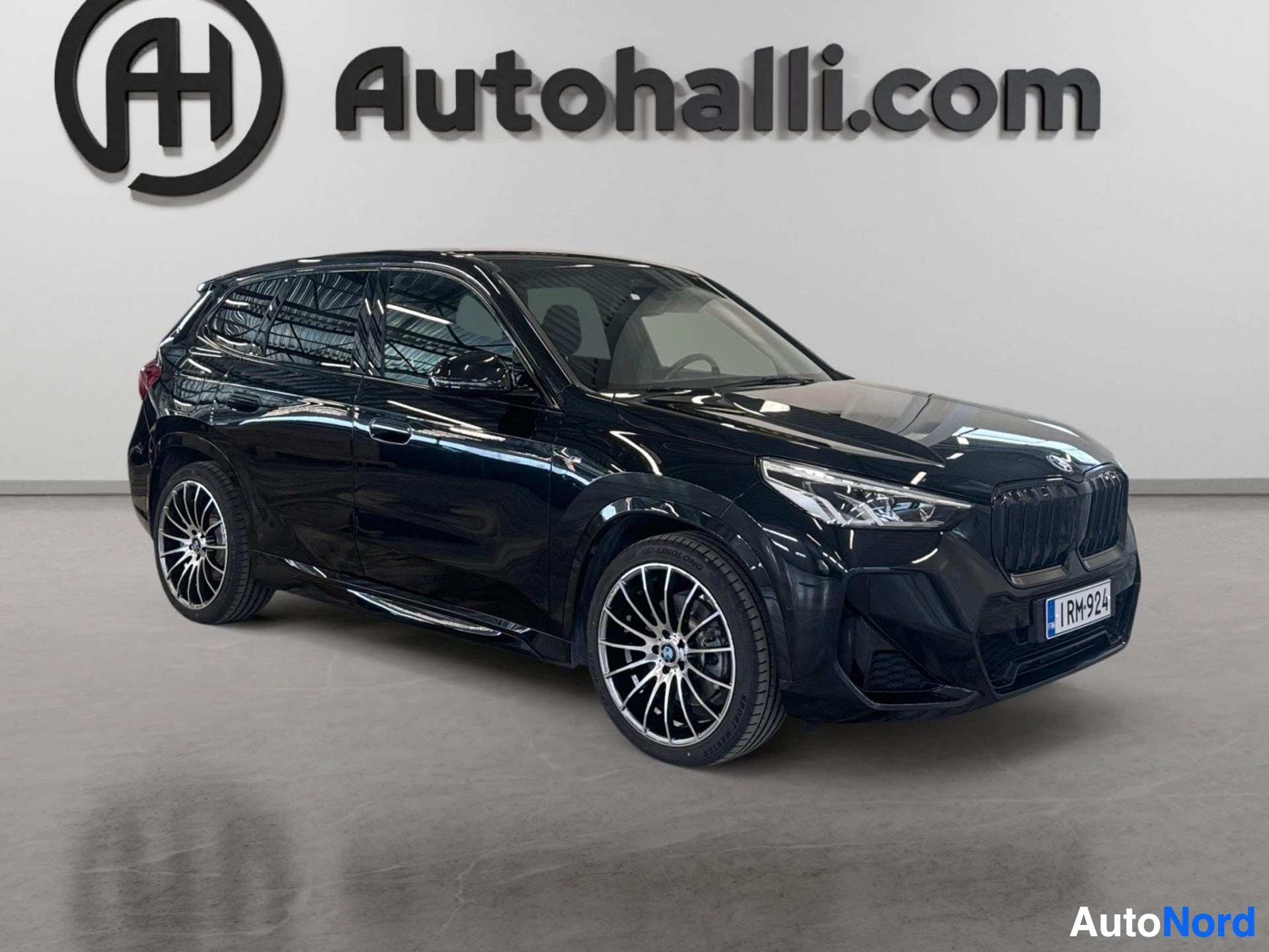 Musta BMW iX1 kolmen neljänneksen näkymä edesta sivulle