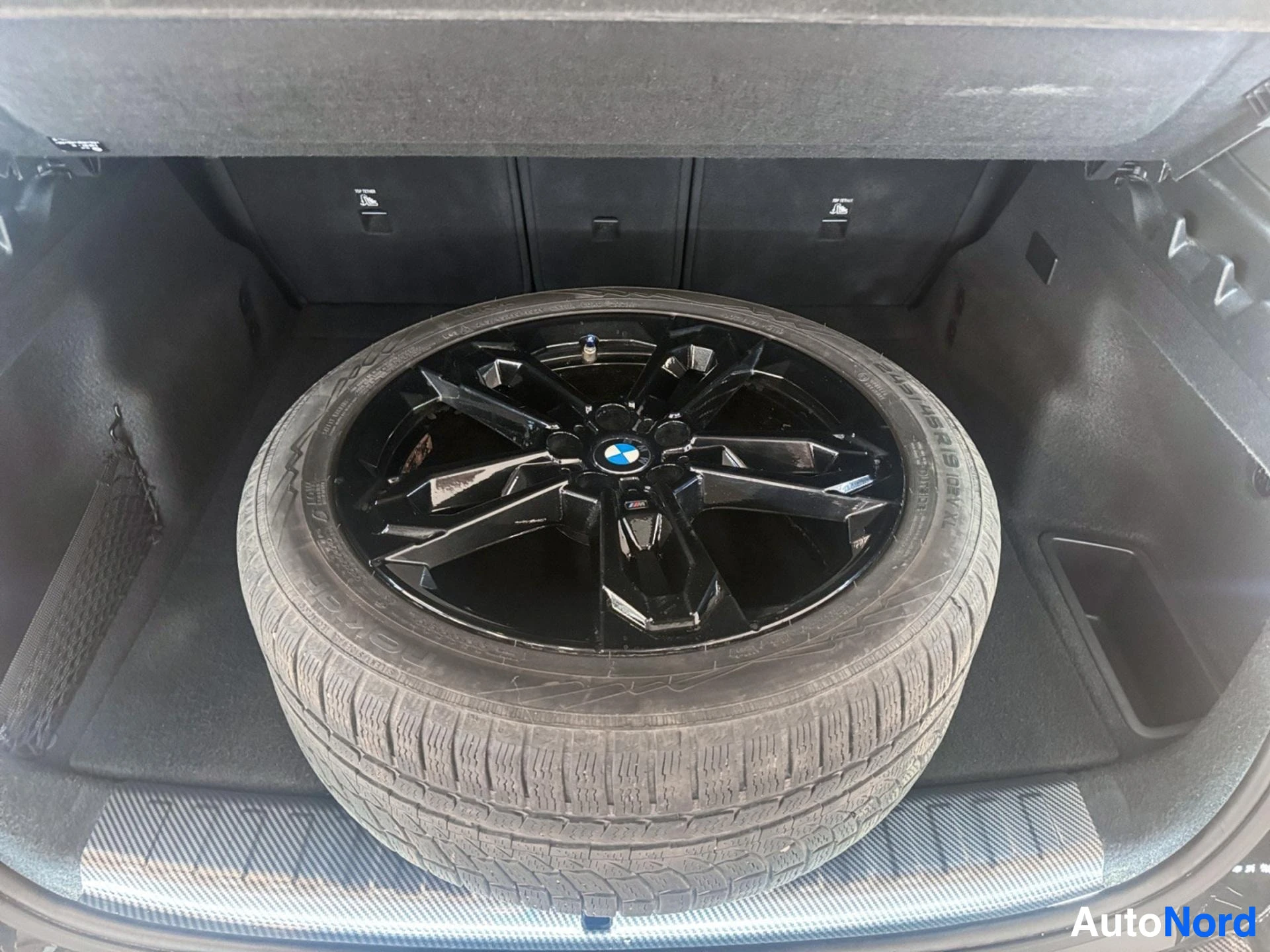 Musta BMW-varaventtiili ja valkorengas tavaratilassa