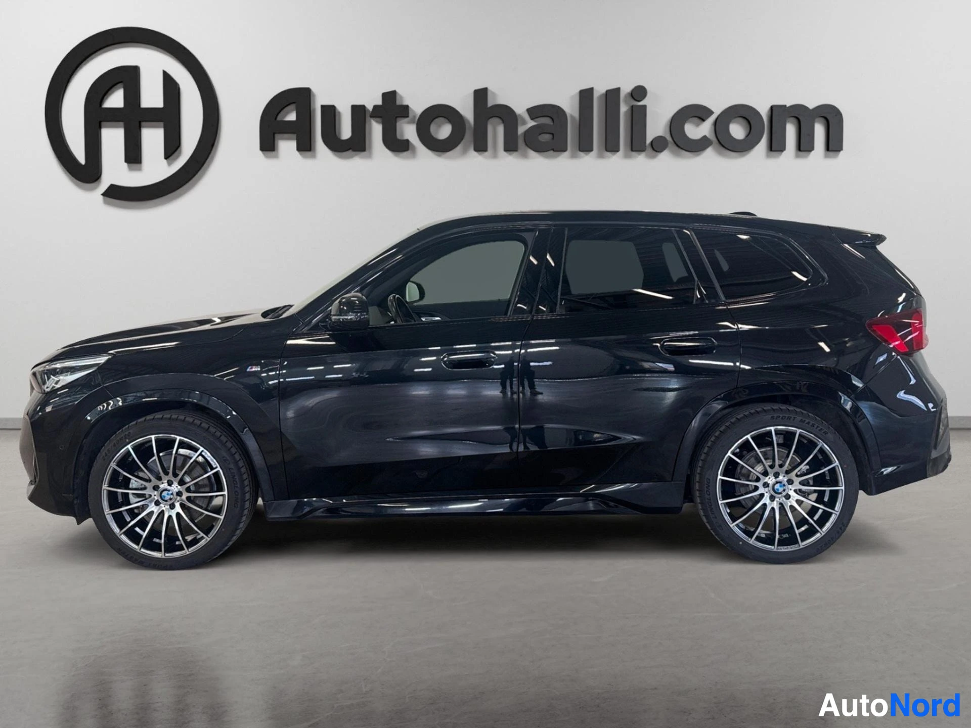 Musta BMW xDrive nelivetoiskulmasuv, näkymä vasemmalta sivulta