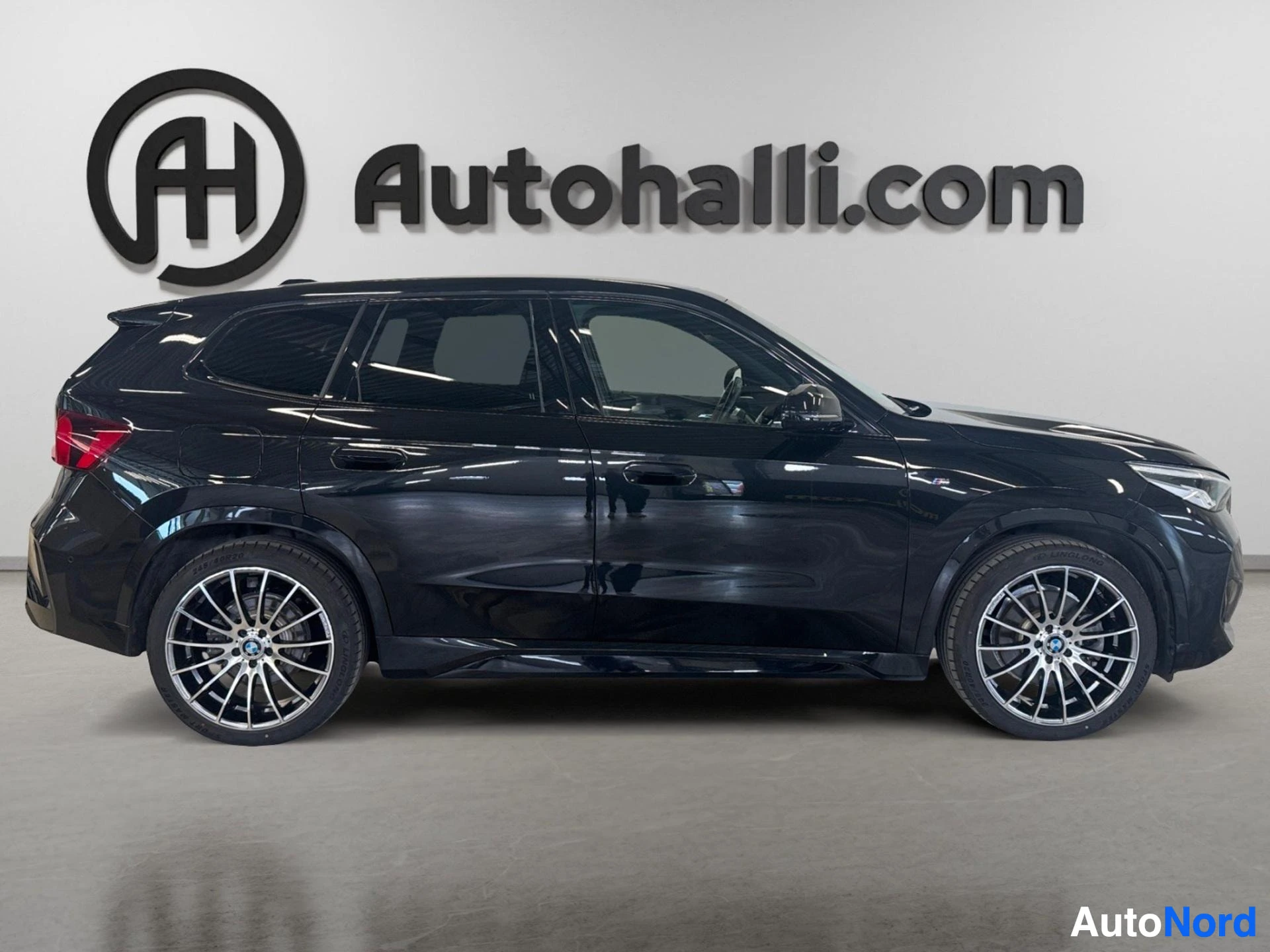 Musta BMW iX1 sivusta, punainen takavalo näkyvissä
