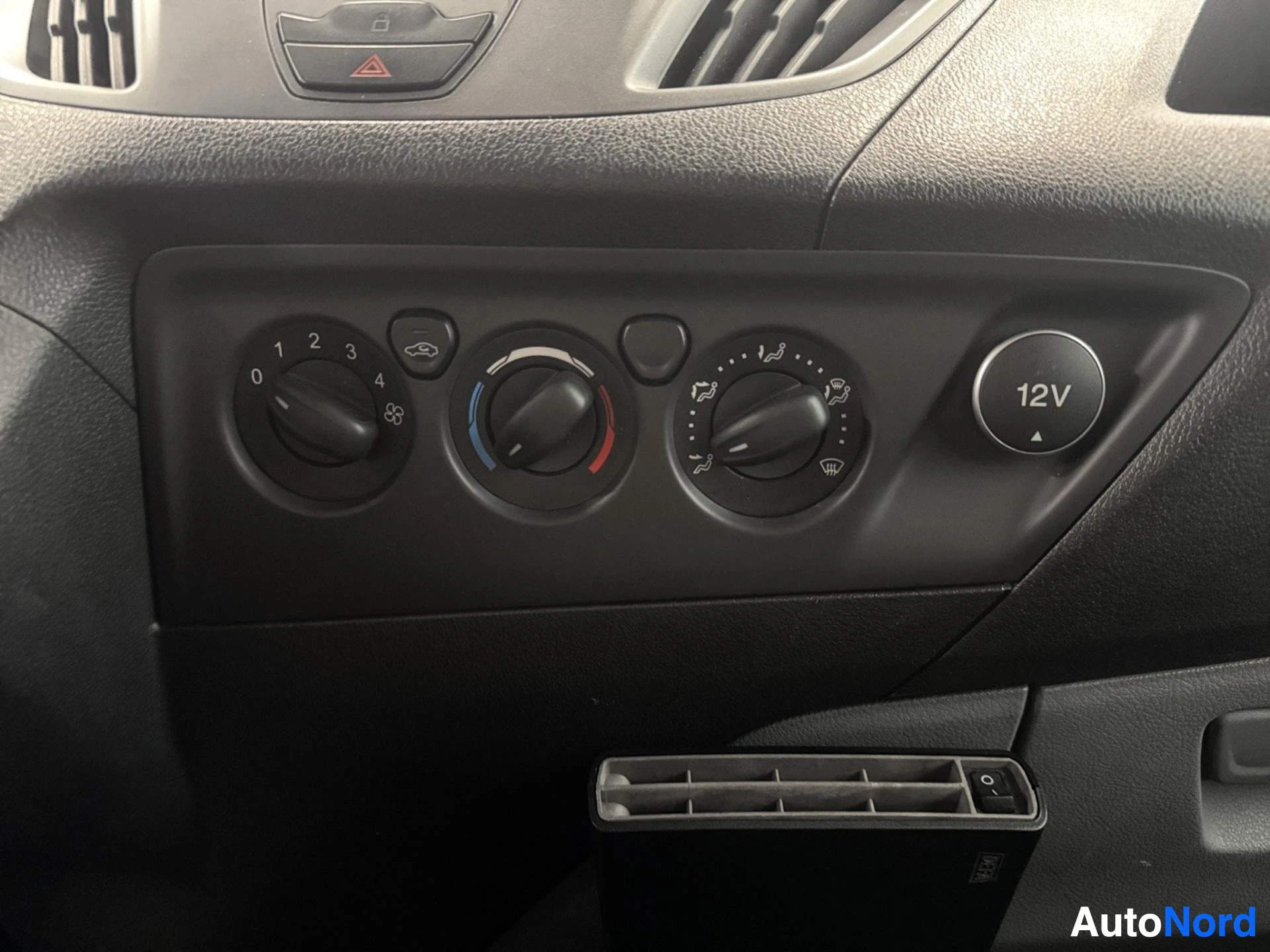 Lower dashboard with climate control knobs and 12V power outlet