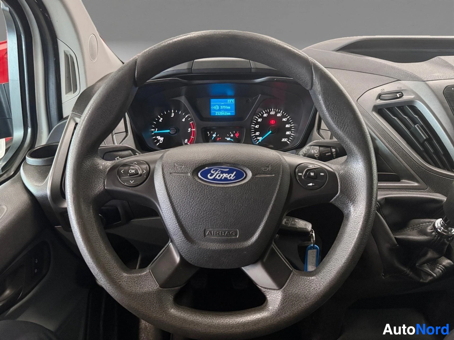 Steering wheel with Ford logo and dashboard instruments behind it