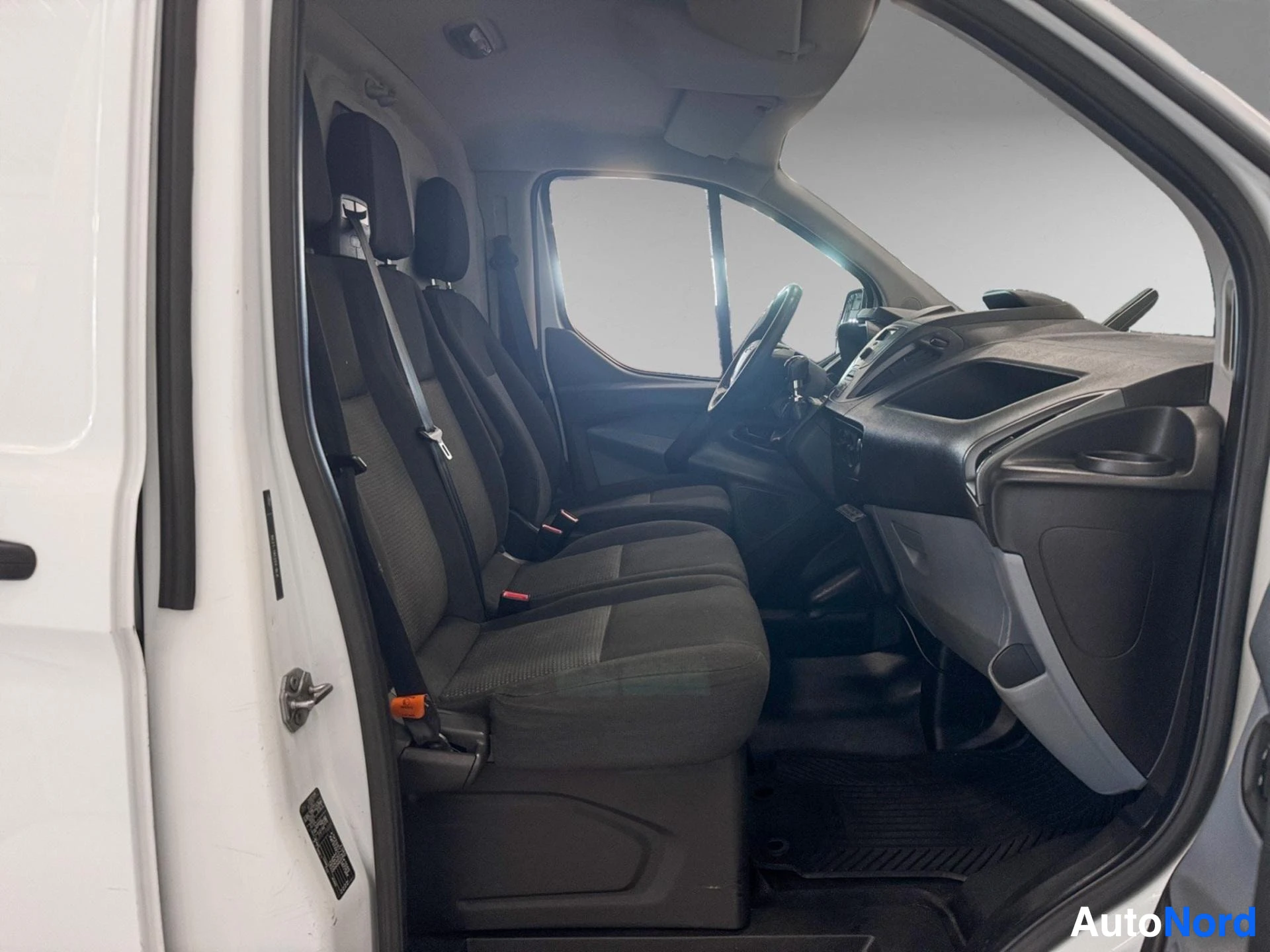 Front cab interior showing driver and passenger seats with open door