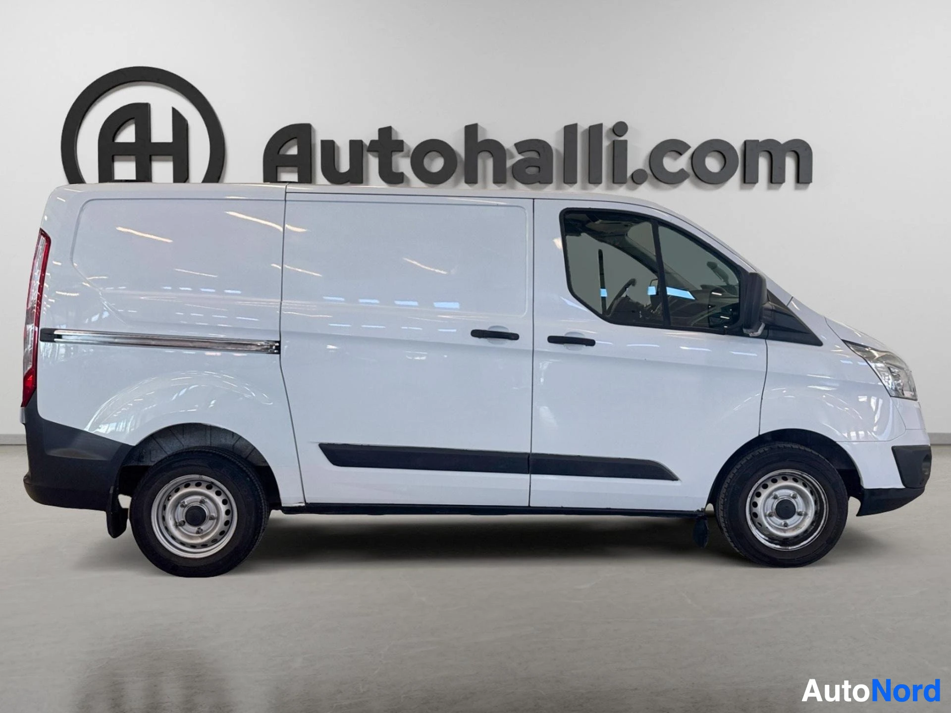 Valkoinen Ford-pakettiauto sivulta, koko auton pituus näkyvissä