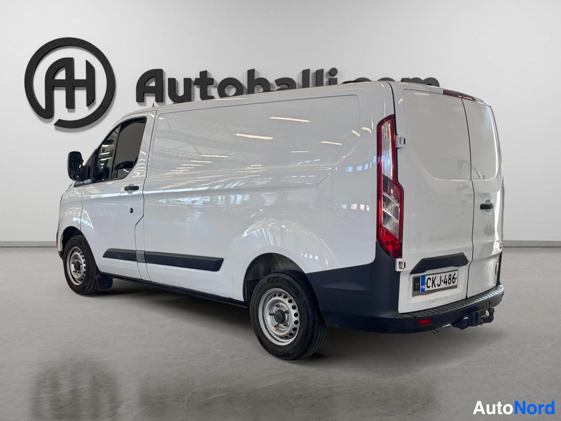 Valkoinen Ford Transit Custom -pakettiauto takaosasta oikealta puolelta, punaisia takavalojakinvestor puolella