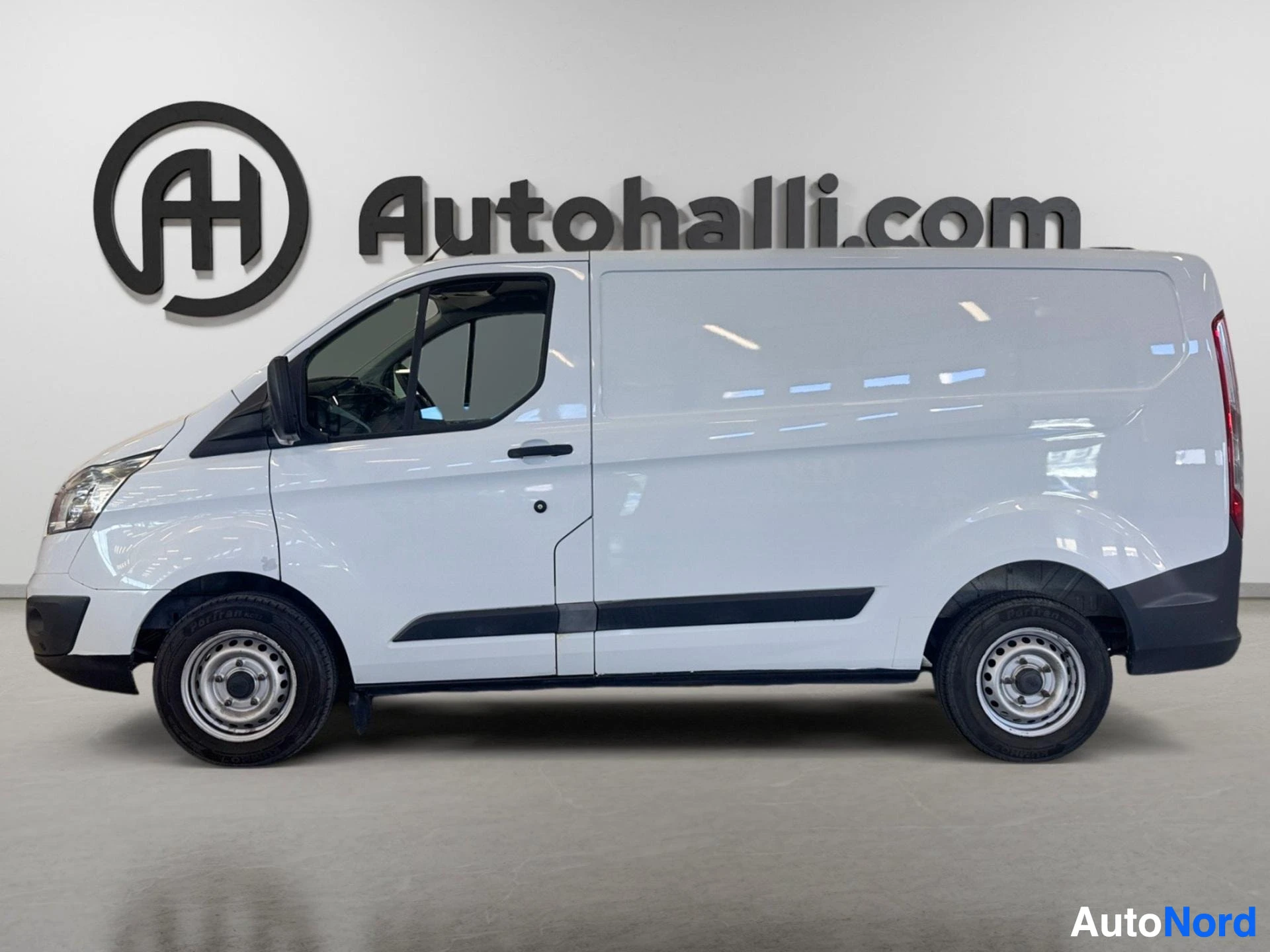 Valkoinen Ford Transit Custom -pakettiauto profiilissa vasemmalta puolelta, avoin kuljettajan ovi