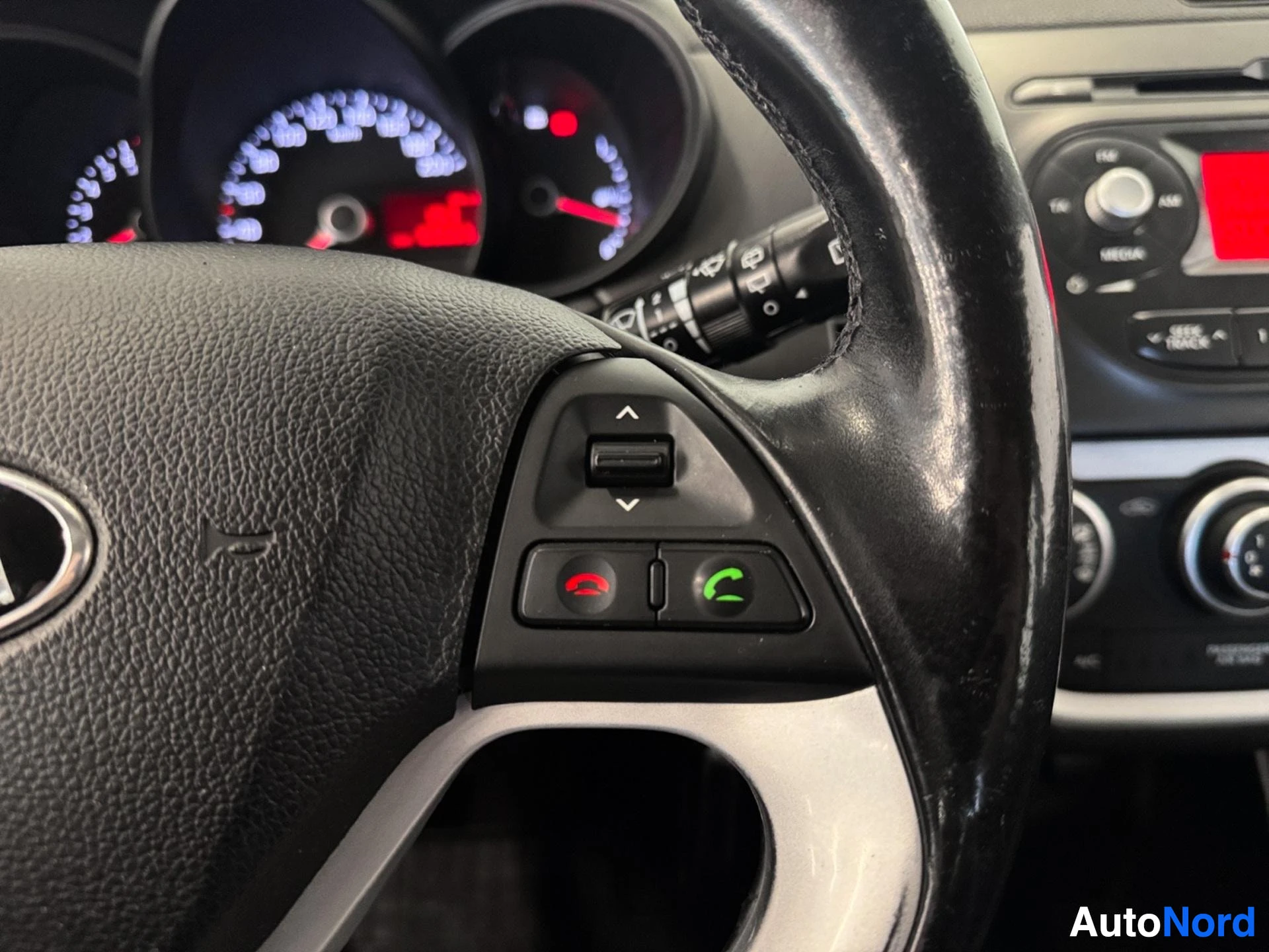 Steering wheel with phone and cruise control buttons, dashboard visible